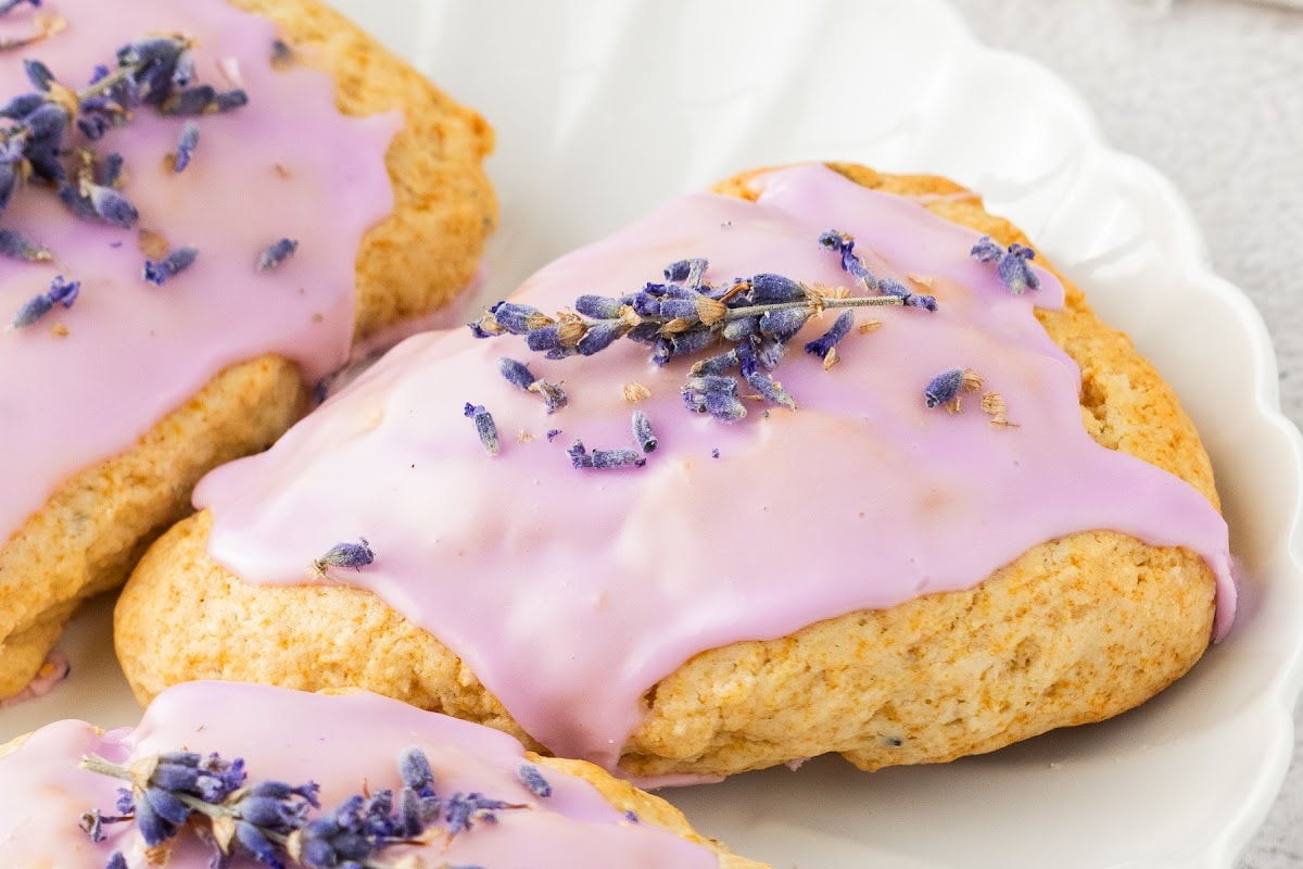 Easy lavender scones with honey glaze and floral topping Close view of easy lavender scones topped with purple berry glaze and dried flowers