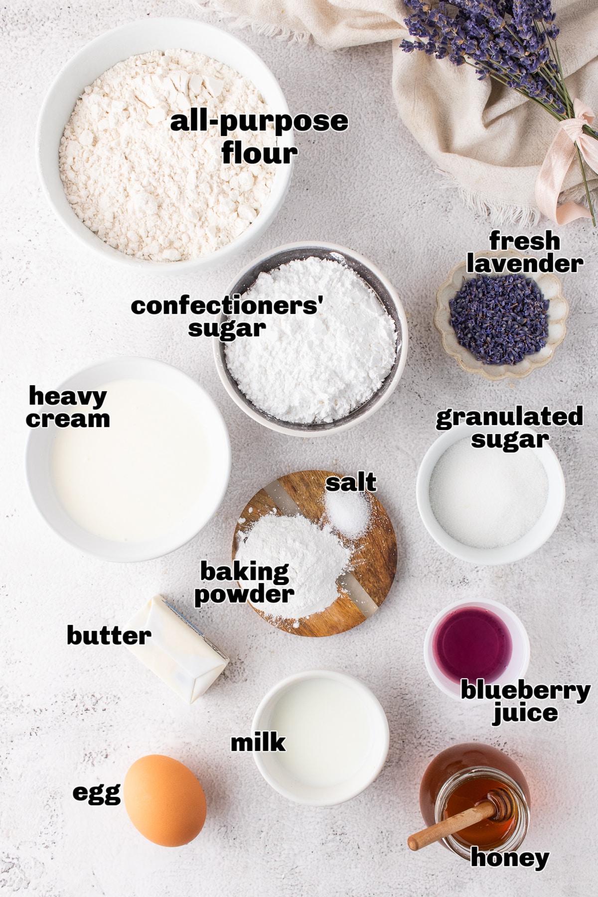 Ingredients laid out for making honey lavender scones with glaze Overhead shot of ingredients for lavender scones including flour, lavender, honey, and cream