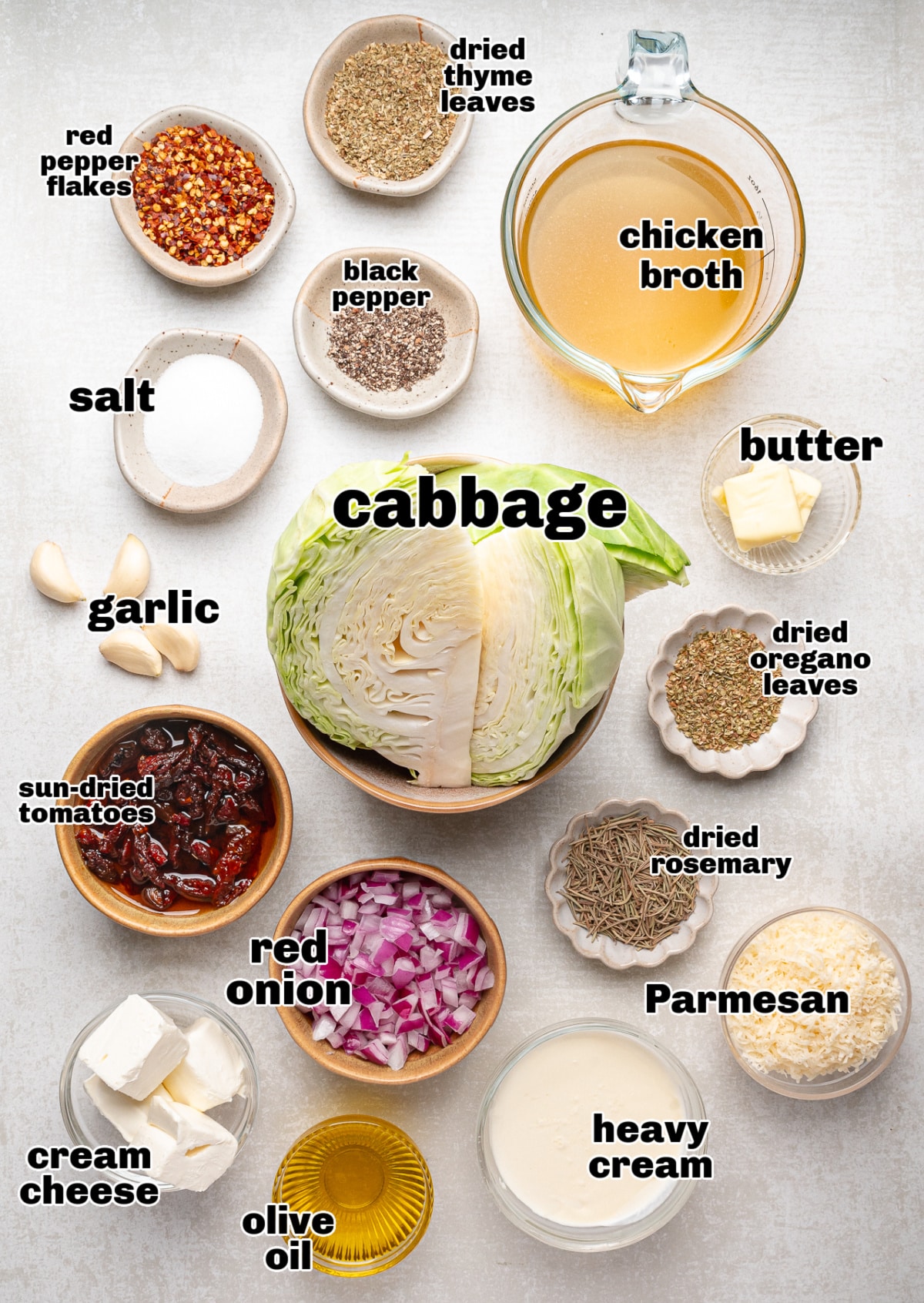Ingredients for baked cabbage with cream cheese and herbs including cabbage, onion, sun-dried tomatoes, and Parmesan.