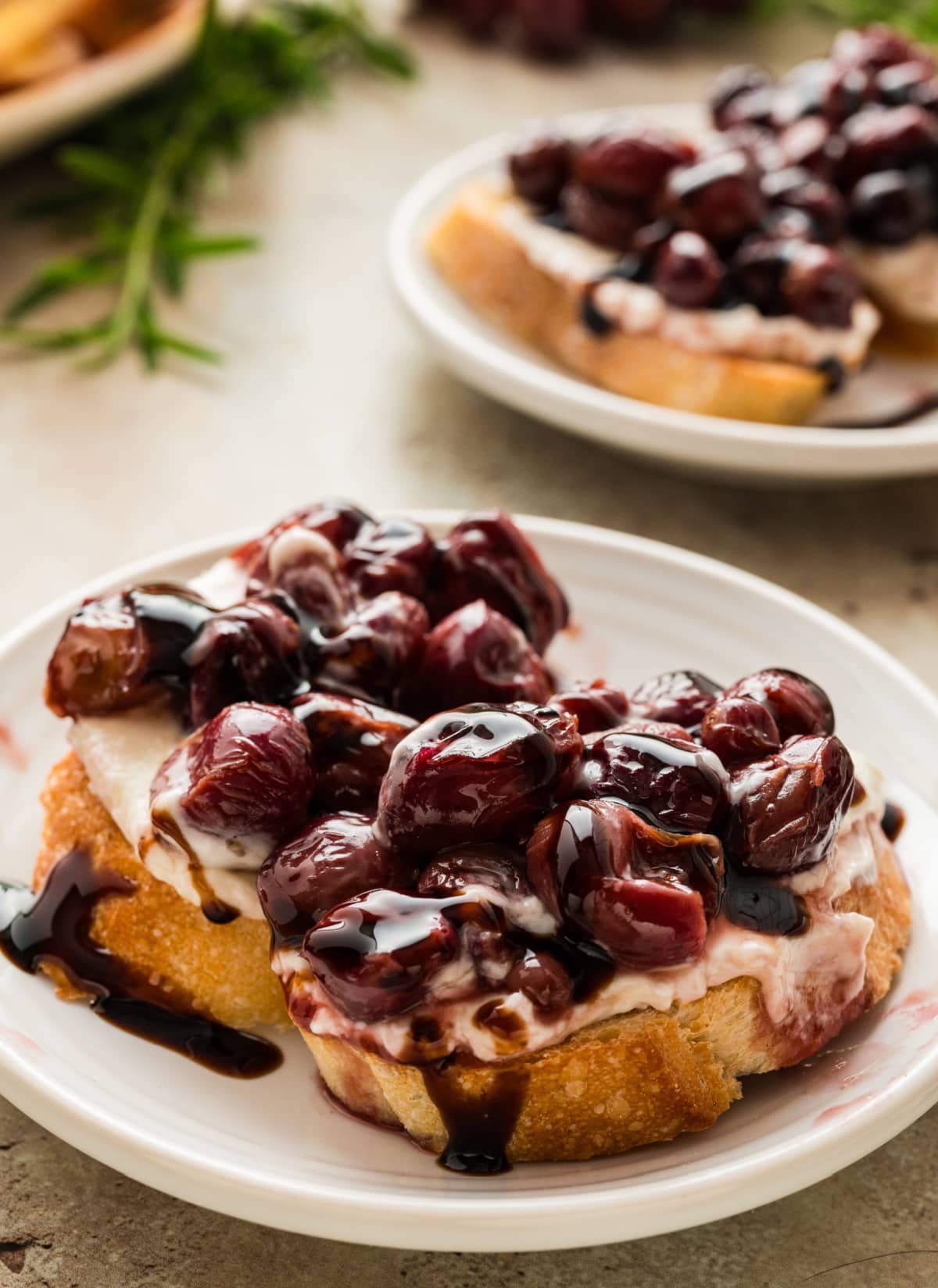 roasted grape and whipped ricotta crostini appetizer with balsamic glaze close-up of honey crostini with whipped ricotta and roasted grape topping drizzled with balsamic