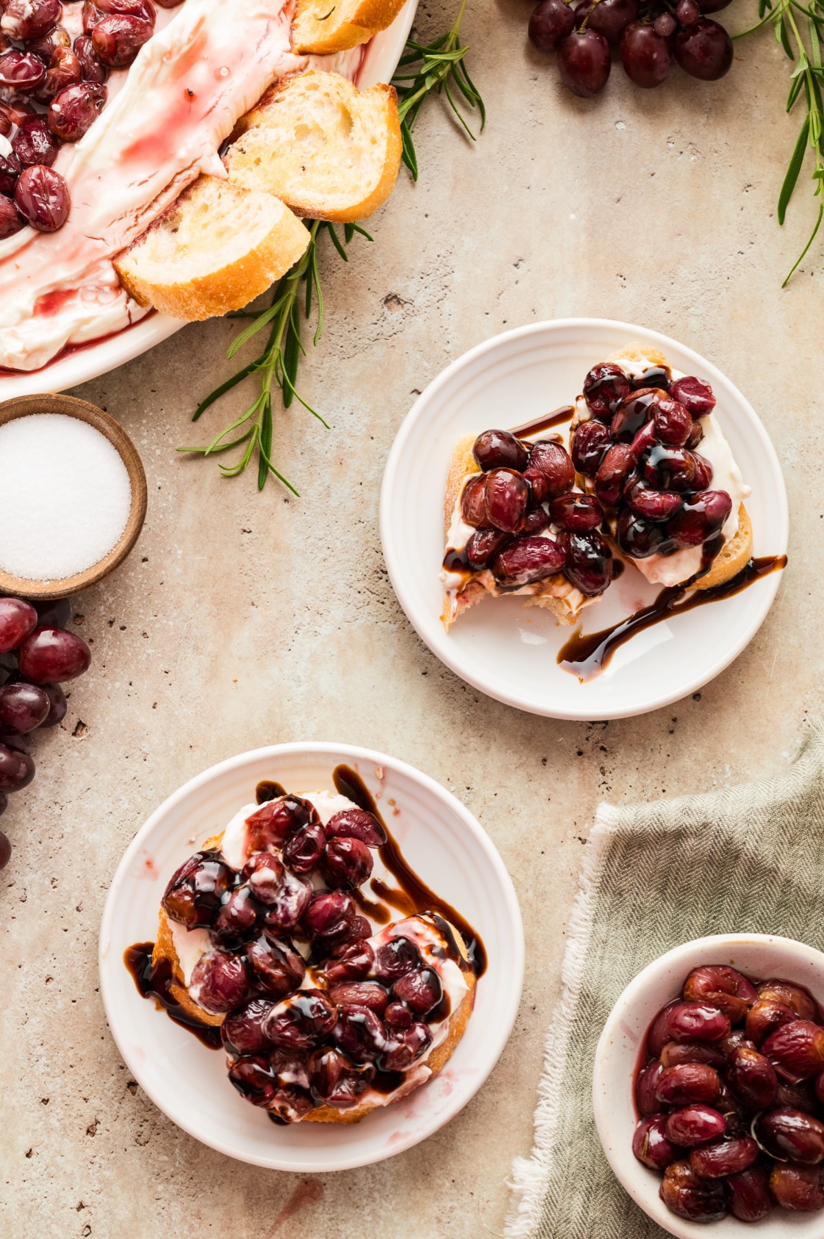 crostini topped with whipped ricotta and balsamic roasted grapes toasted crostini topped with whipped ricotta and roasted grapes on white plates