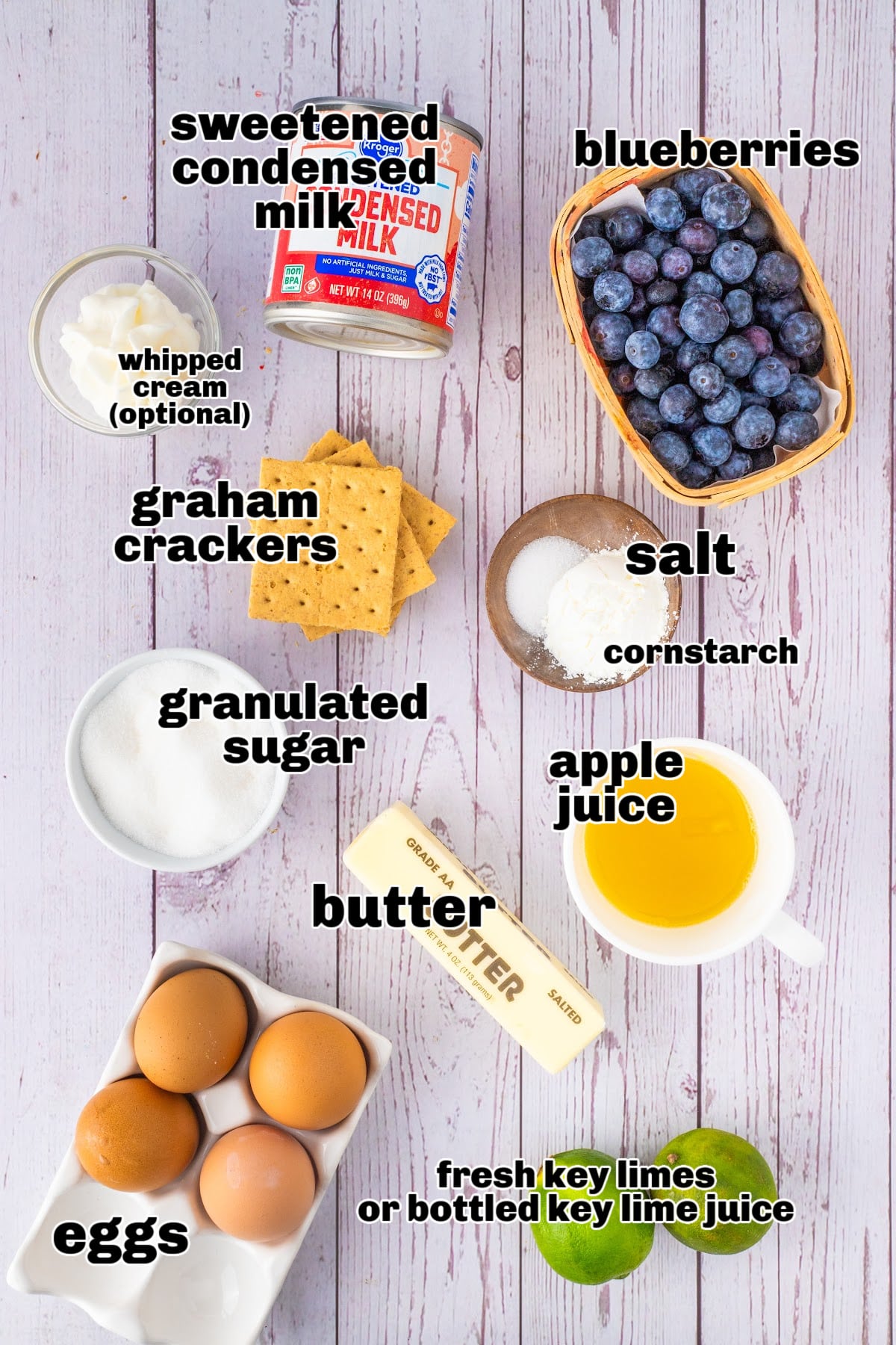 Citrus and blueberry tart ingredients on table. Ingredients for citrus and blueberry tart including graham crackers, blueberries, limes, and condensed milk.