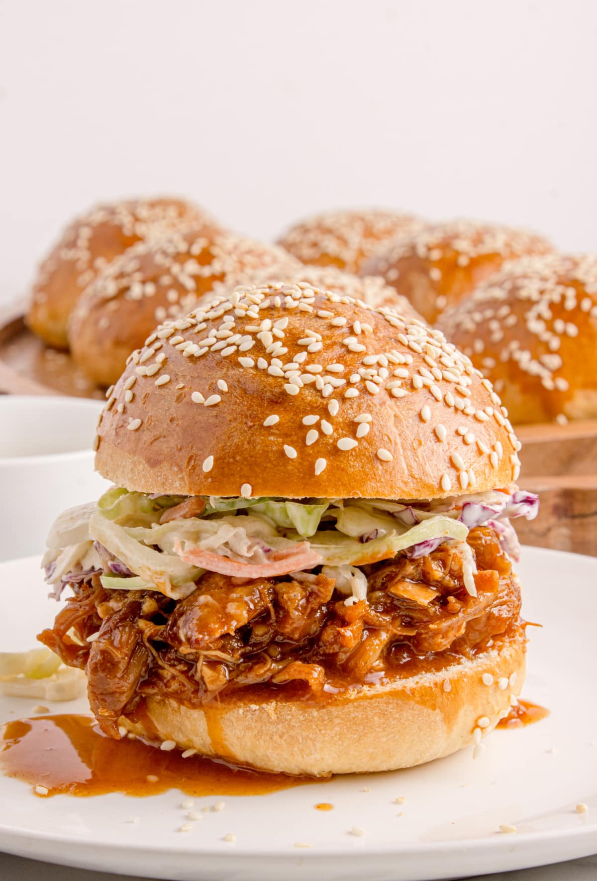 Homemade slider bun filled with Korean bbq chicken Korean bbq chicken with coleslaw on a homemade sesame slider bun