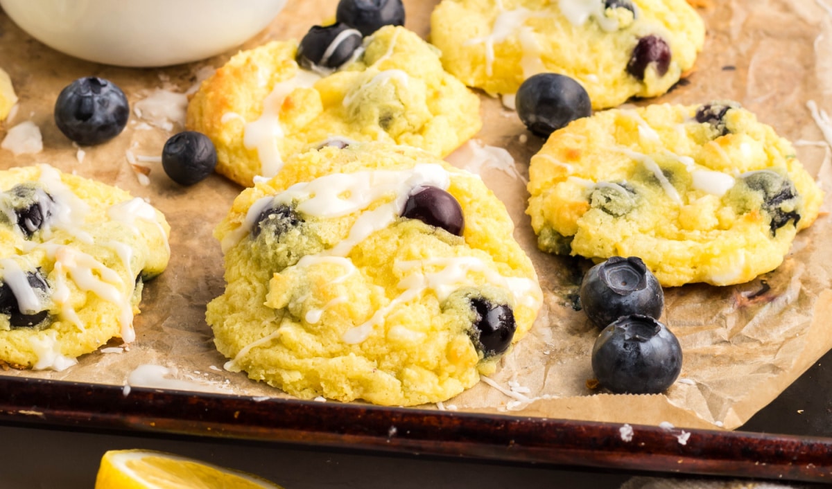 Baked Lemon Blueberry Cookies Closeup Closeup of blueberry lemon cookies with fresh blueberries and lemon icing on a baking sheet