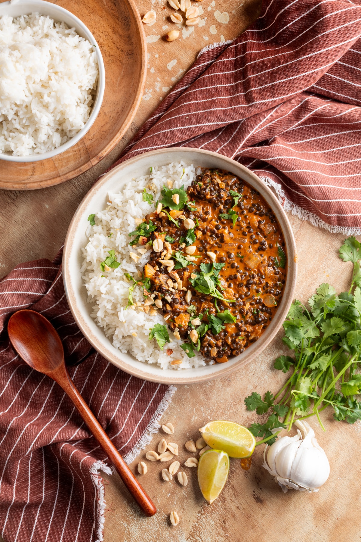 Lentils served in a bowl with rice, topped with cilantro and chopped peanuts.