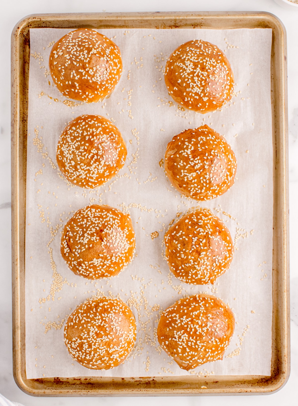 Fresh homemade slider buns with sesame seeds Tray of eight homemade slider buns baked until golden brown