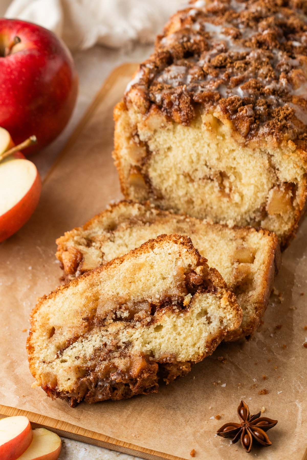 Amish apple fritter bread sliced to show chunks of apples and cinnamon swirl with glaze on top.