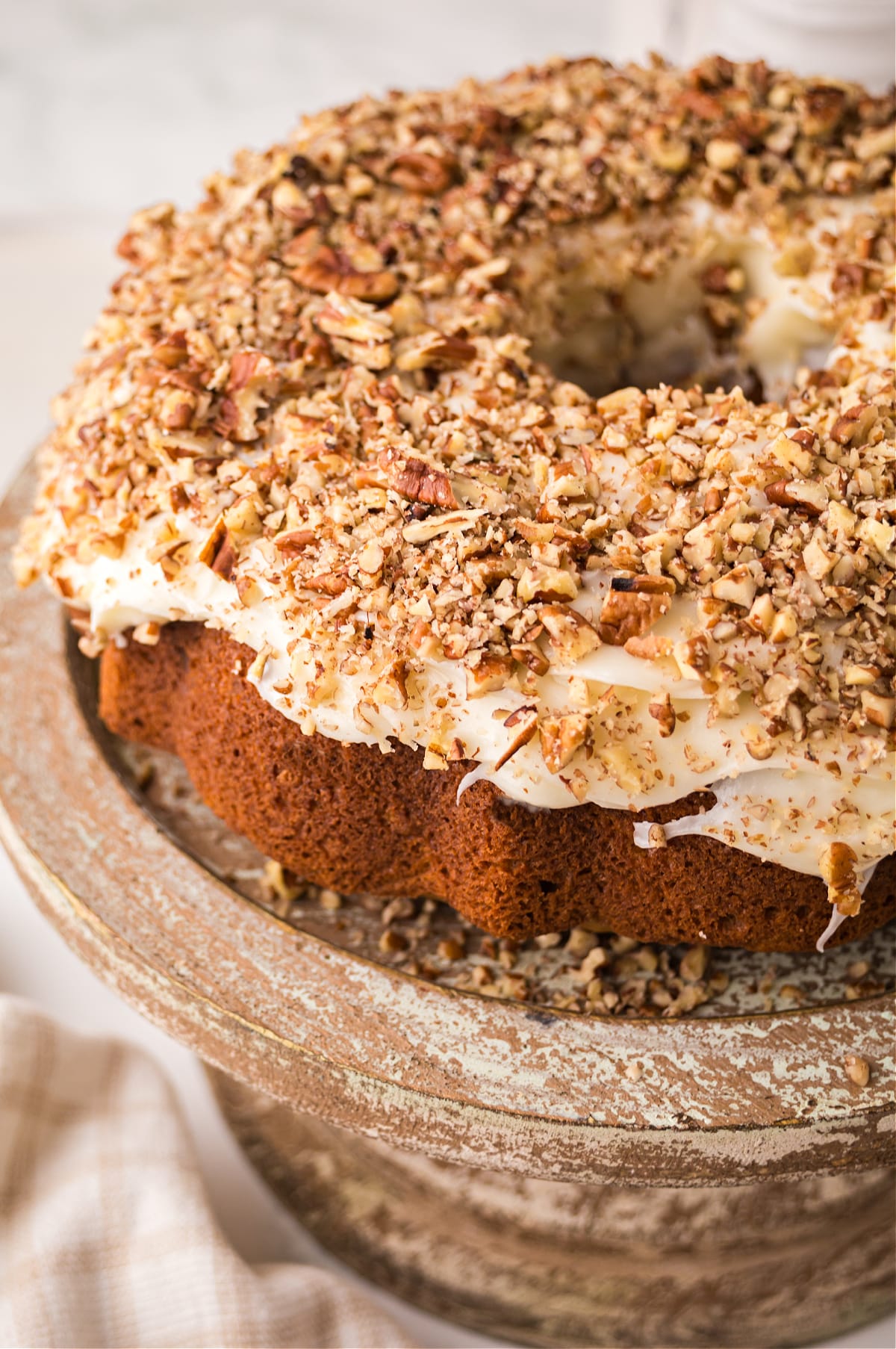 carrot bundt cake with cream cheese frosting Carrot bundt cake with cream cheese frosting and chopped walnuts on top.