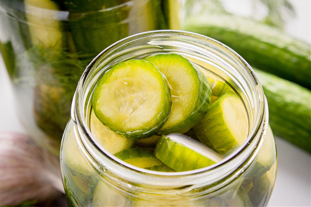 Fresh cucumber coins in brine with garlic and dill.