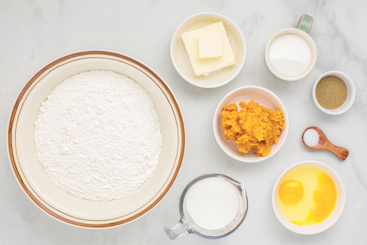 Butternut squash cinnamon rolls ingredients. Ingredients for making soft fall cinnamon rolls including flour, eggs, butter, yeast, sugar, and squash purée.