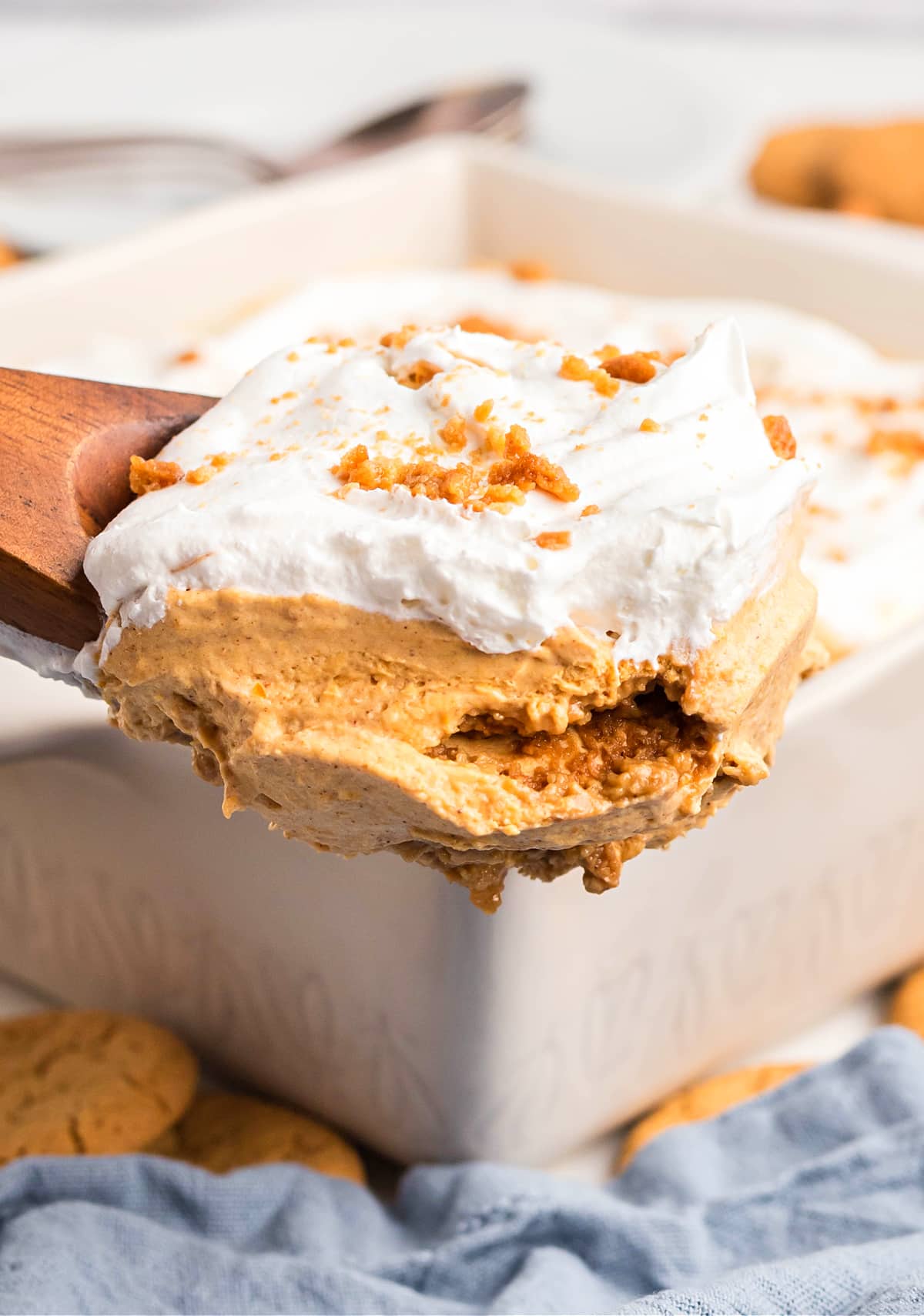 Pumpkin cream dessert lifted from pan showing soft cookie layers