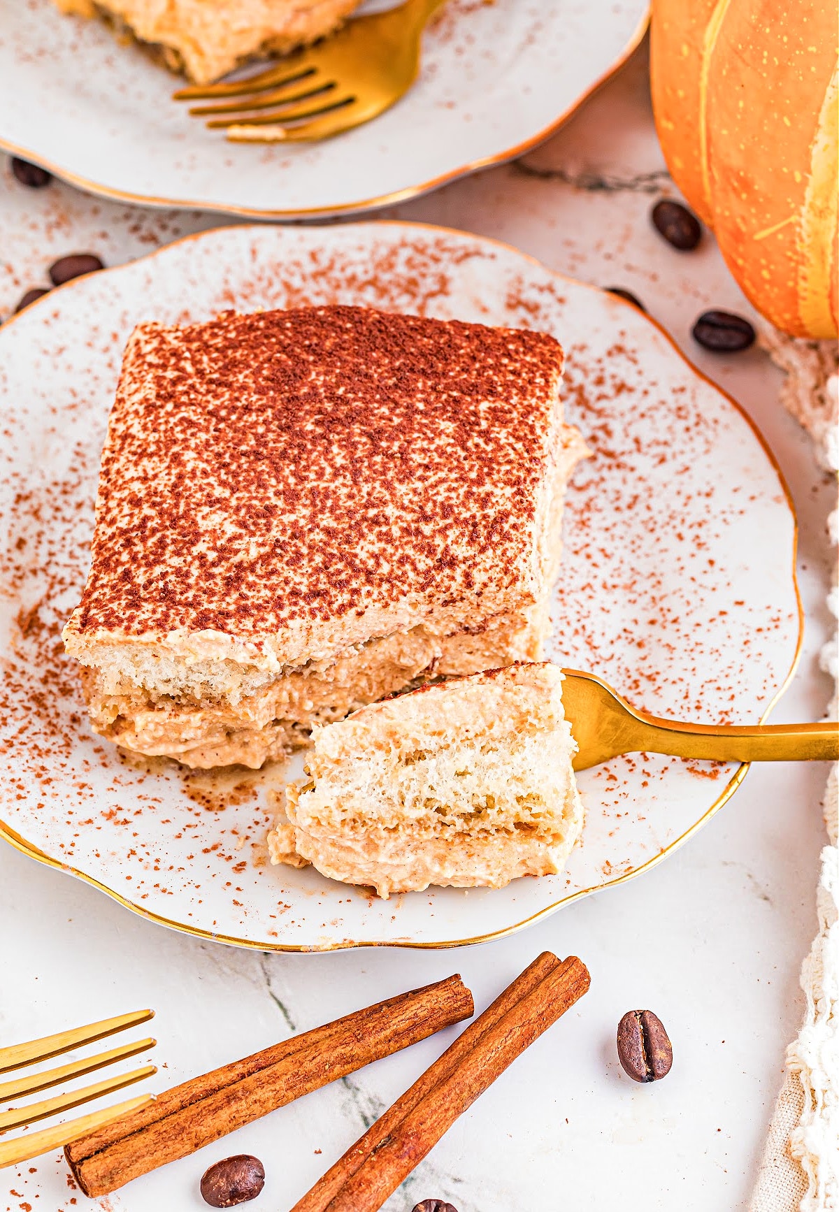 easy pumpkin tiramisu Pumpkin tiramisu slice on white plate dusted with cocoa powder