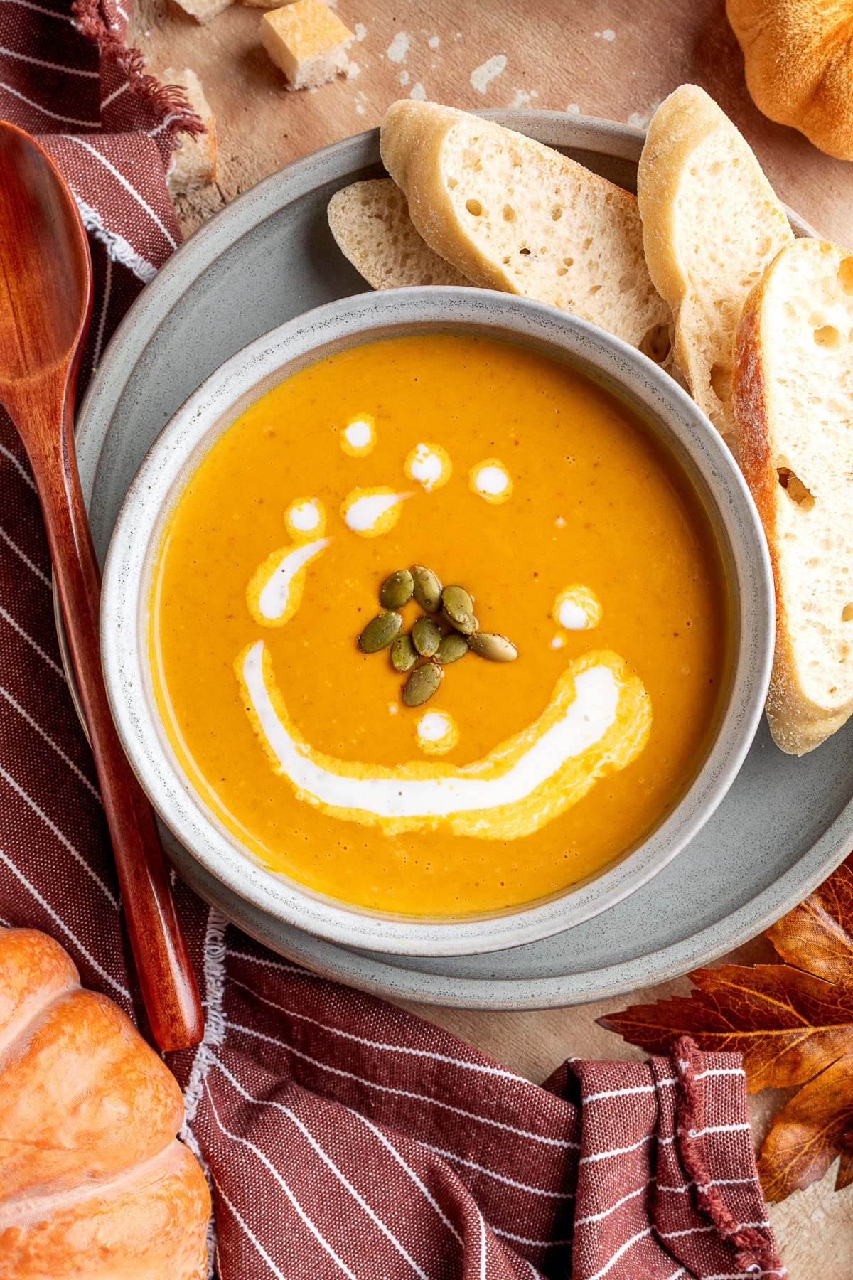 pumpkin soup with bread pumpkin soup with roasted garlic served in a bowl with a slice of crusty bread on the rim