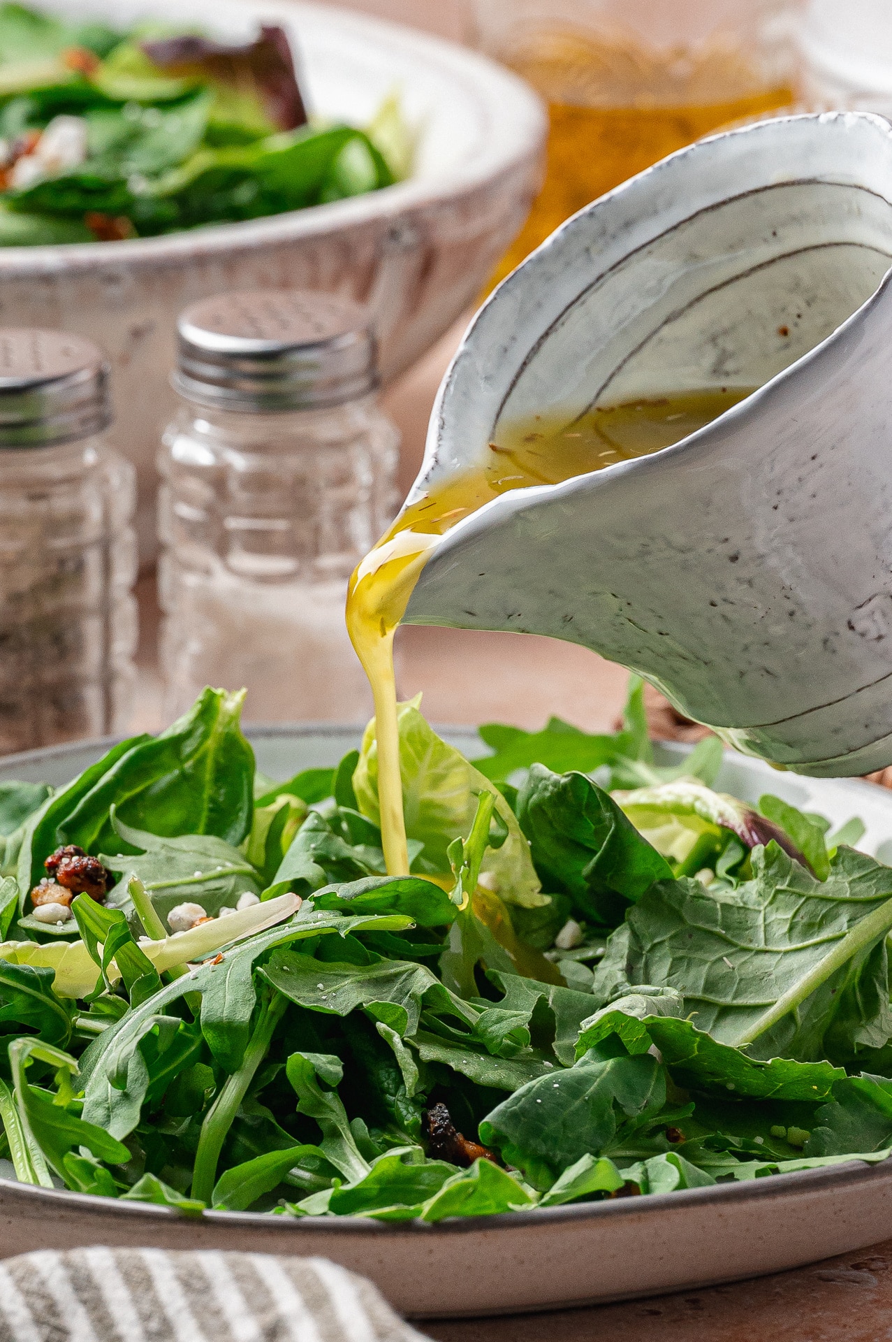 White Balsamic Vinaigrette for Salads Drizzling vinaigrette over greens with walnuts and cheese crumbles