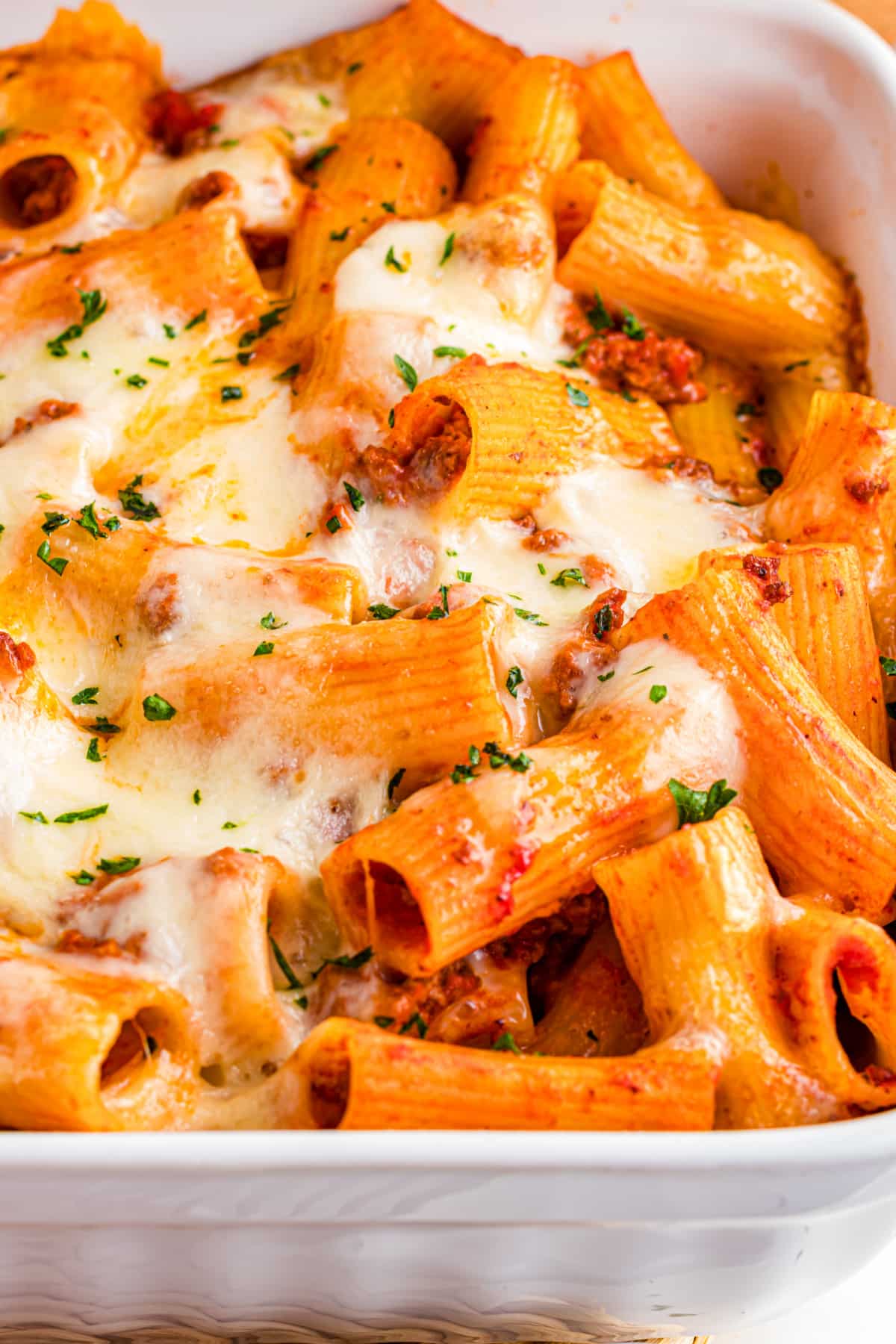 Close-up of rigatoni pasta with melted mozzarella, beef sauce, and golden edges fresh from the oven
