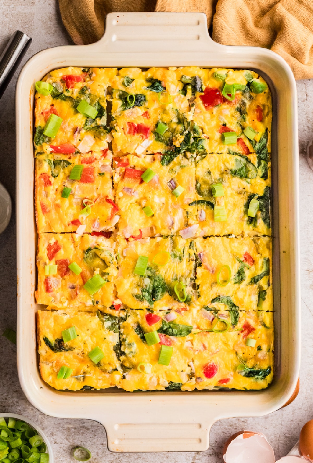 Cottage cheese egg bake in pan cut into pieces Cottage cheese egg bake baked in a dish with spinach, peppers, and cheddar cut into squares