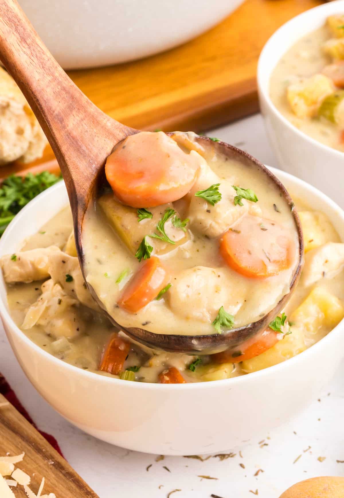 one pot chicken stew in ladle ladle of one-pot chicken stew with carrots, potatoes, and chunks of chicken in a thick creamy broth, topped with parsley.