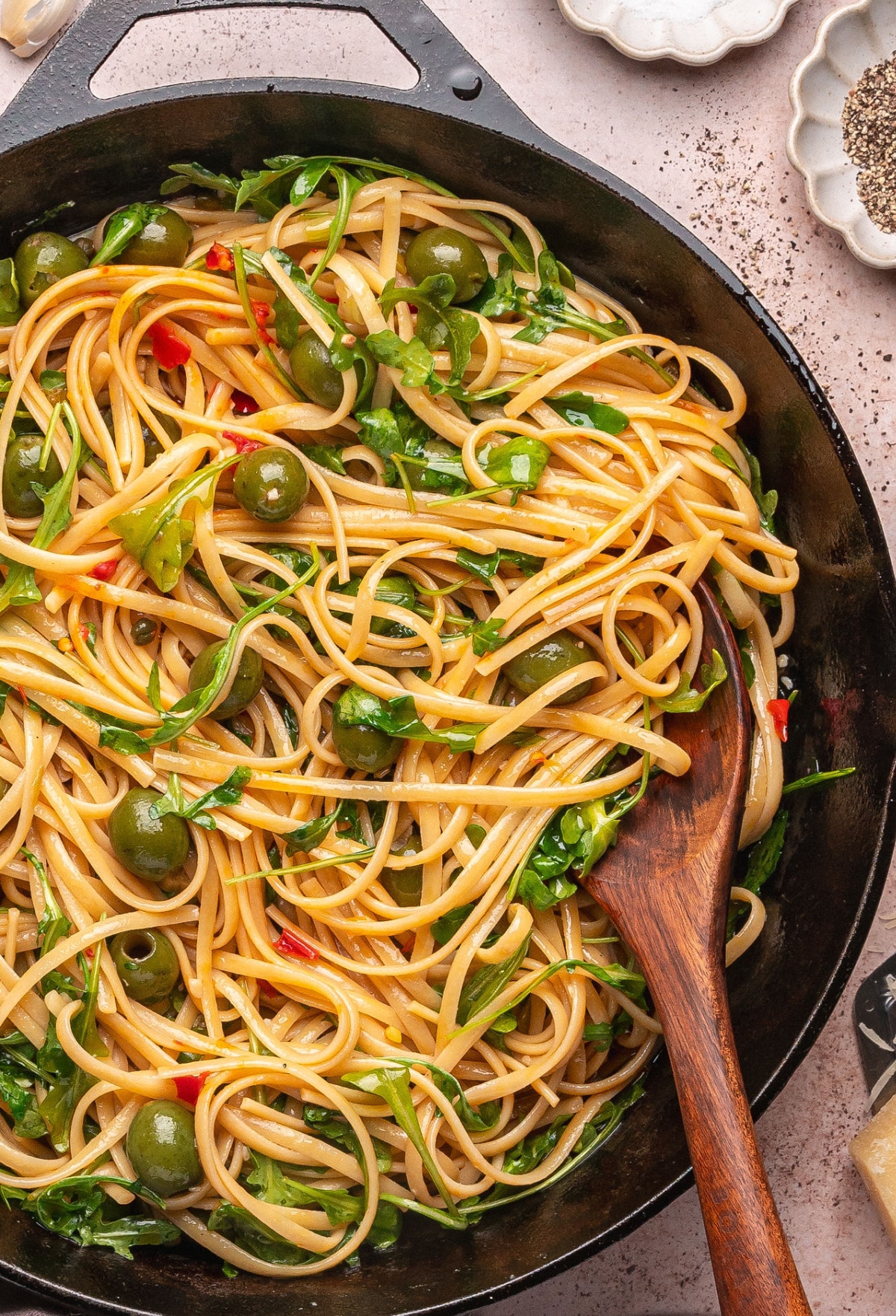 tomato-free-puttanesca-skillet-green-olive-pasta Tomato-free puttanesca in a black skillet with linguine, Castelvetrano olives, and fresh arugula.
