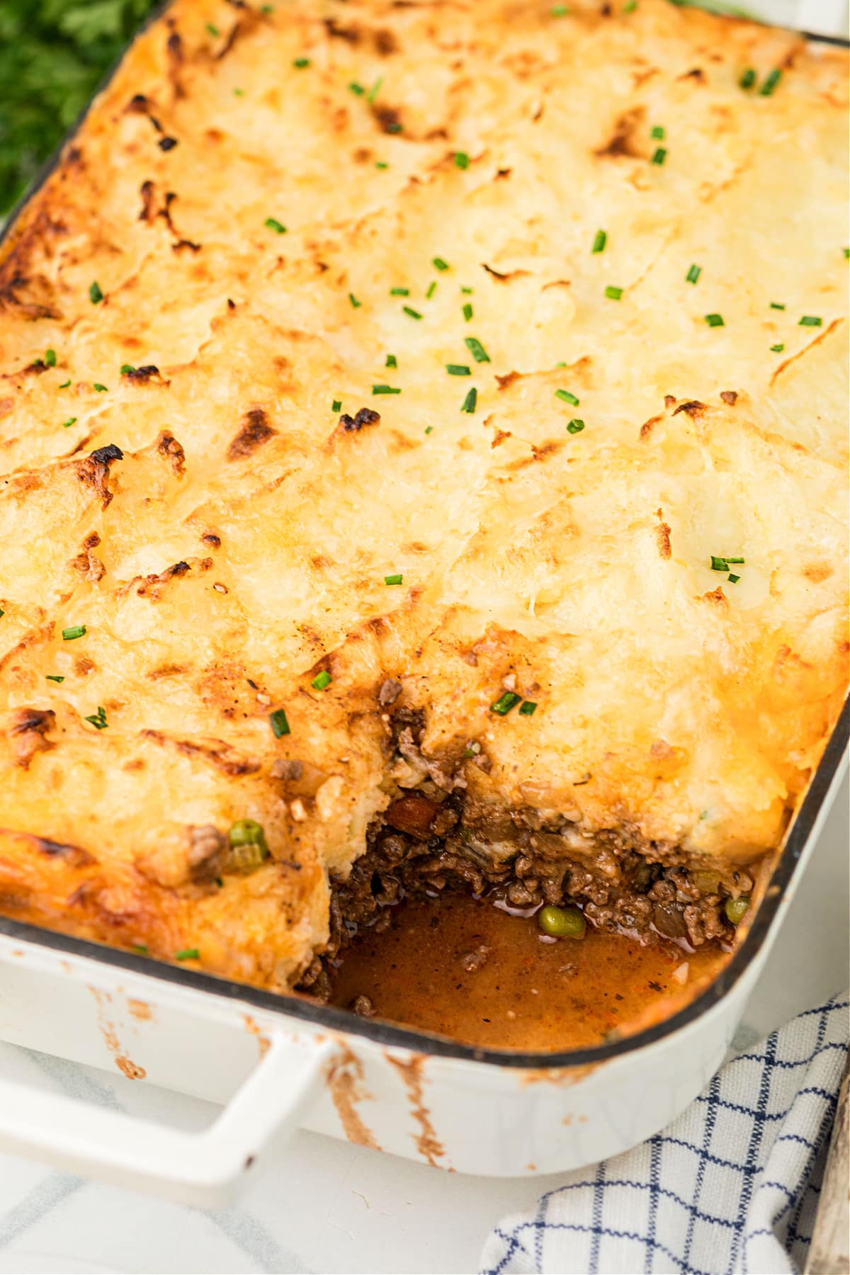 hearty beef and potato bake with golden topping Hearty beef and vegetable bake topped with golden mashed potatoes, freshly baked and slightly browned on top.