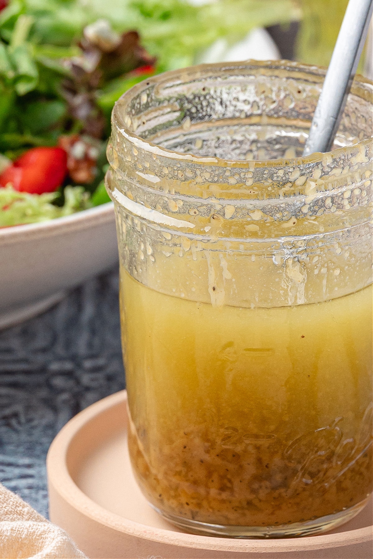Honey Champagne Vinaigrette in Jar Honey champagne vinaigrette in a glass jar with visible mustard and pepper, ready to pour over salad greens.