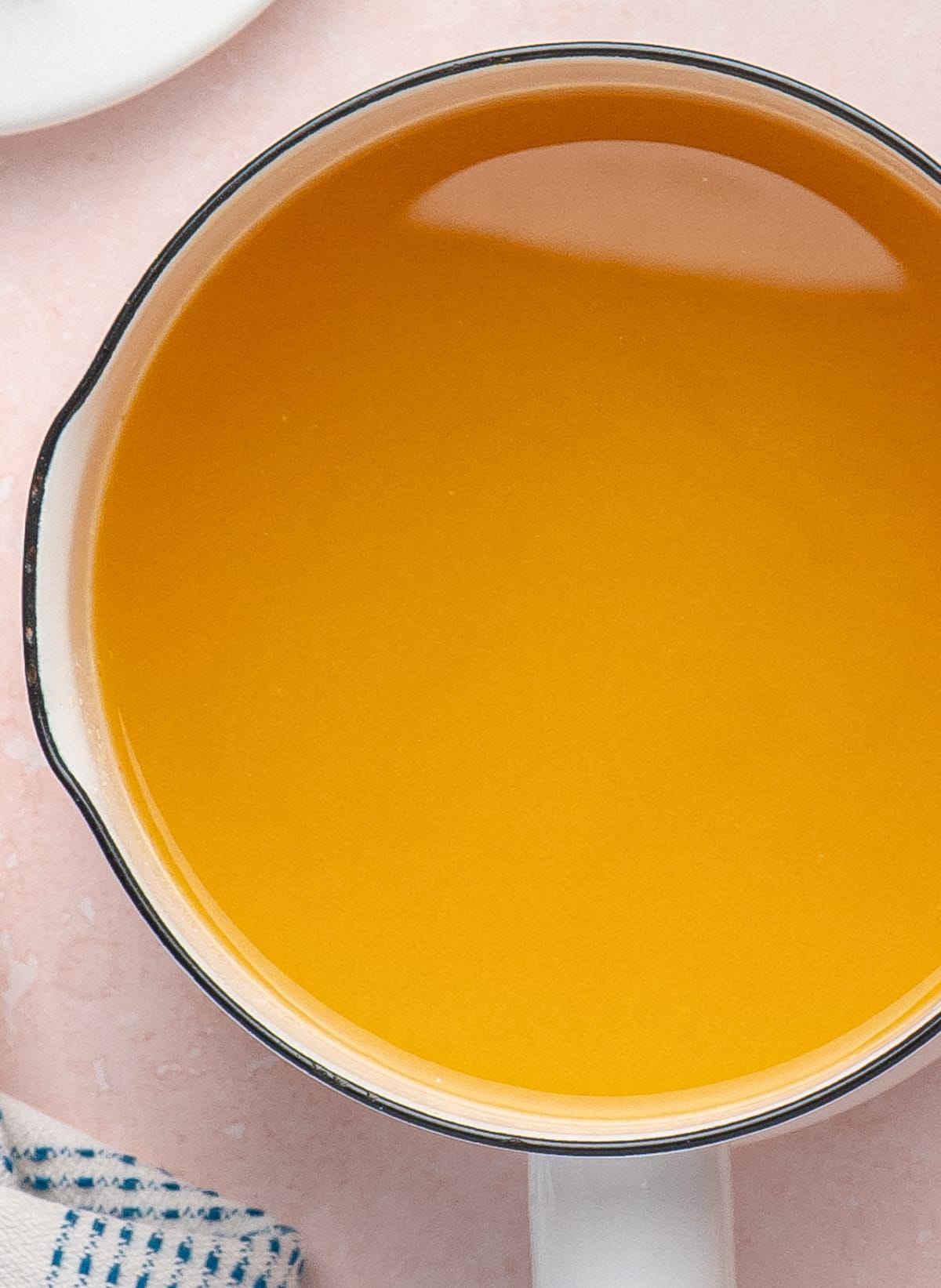 Warm pineapple hot sauce mixture simmering in a white saucepan before blending.
