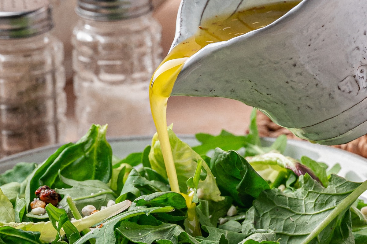 White Balsamic Vinaigrette Recipe Pouring white balsamic vinaigrette over fresh green salad