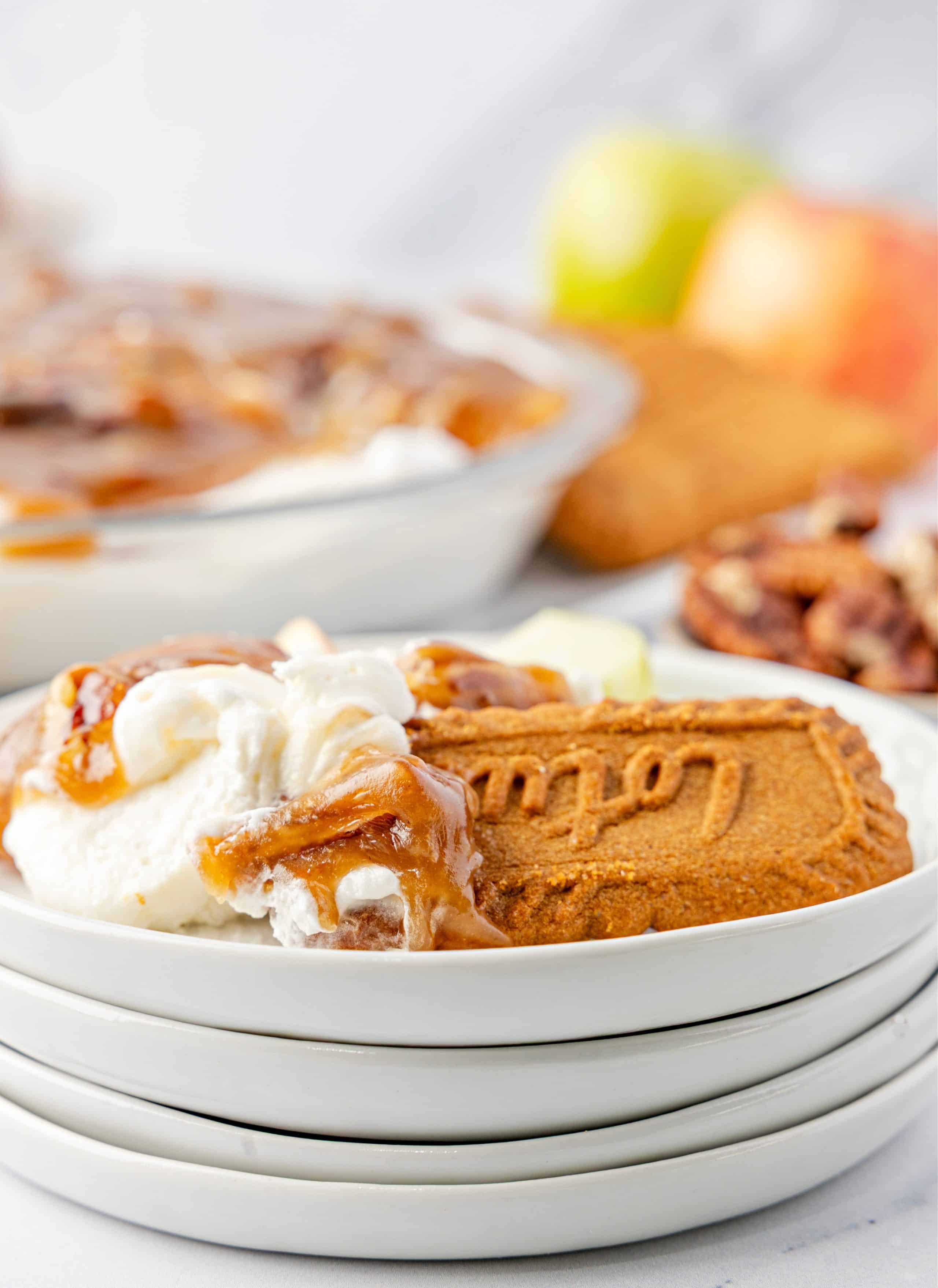 Plate with caramel pecan topping and cream cheese dip with a Biscoff cookie Serving of cream cheese dessert dip topped with warm caramel pecans on a small plate with a Biscoff cookie, showing the soft, scoopable texture.