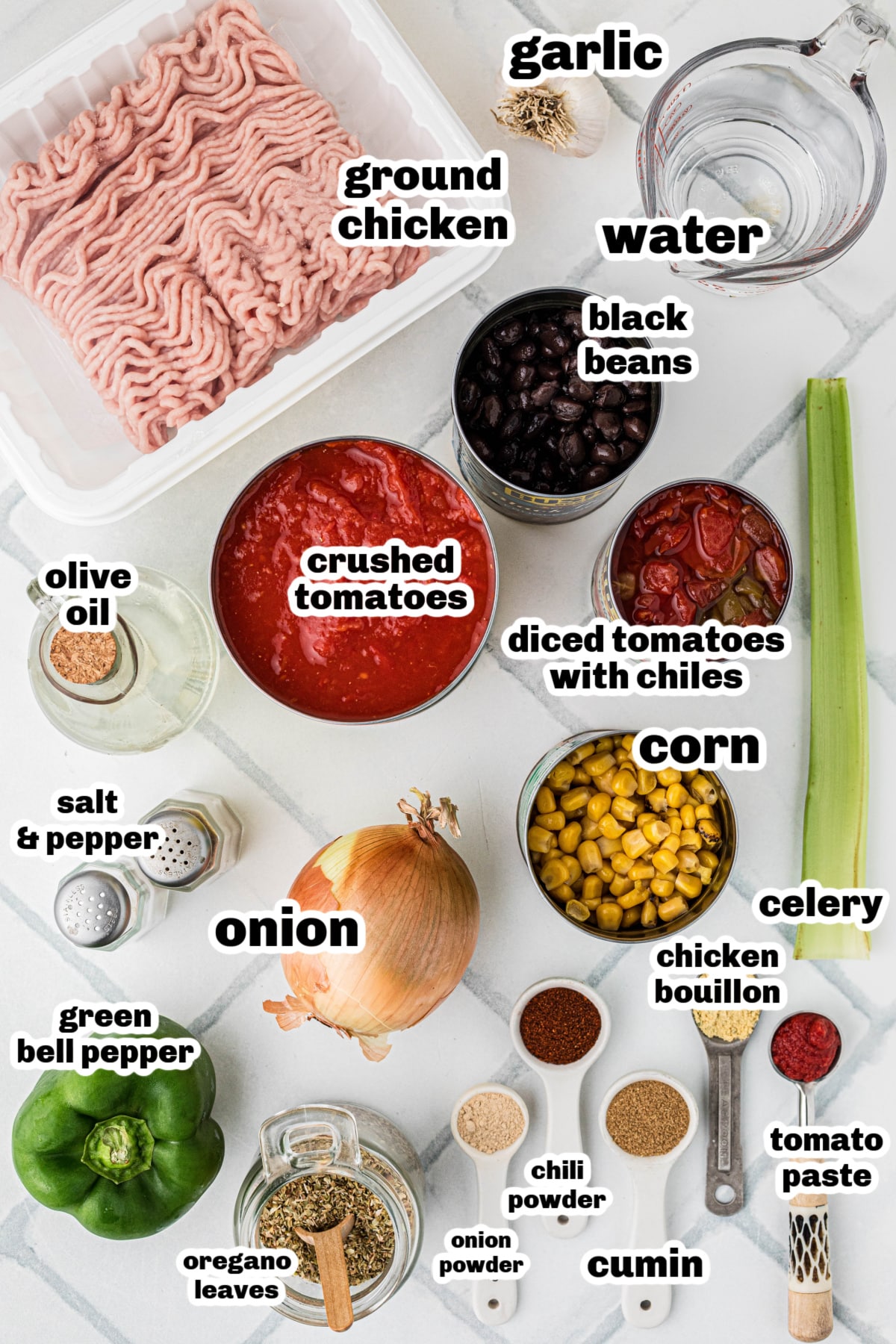 Ingredients for ground chicken chili arranged on a counter, including ground chicken, crushed tomatoes, black beans, corn, diced tomatoes with chiles, spices, and vegetables.