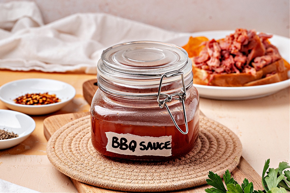 Western Carolina BBQ sauce in glass jar with label. Jar of Western Carolina vinegar BBQ sauce labeled “BBQ Sauce,” for Noble Pig.