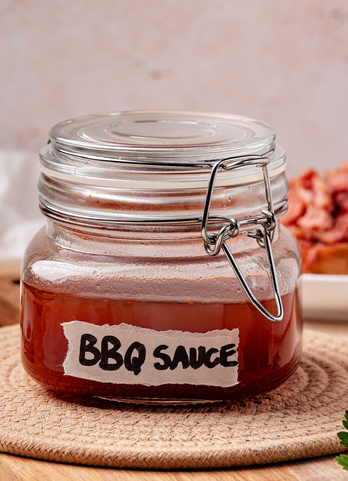 Western Carolina BBQ sauce in jar close-up. Close-up of Western Carolina BBQ sauce in a glass jar labeled BBQ Sauce on a woven mat.