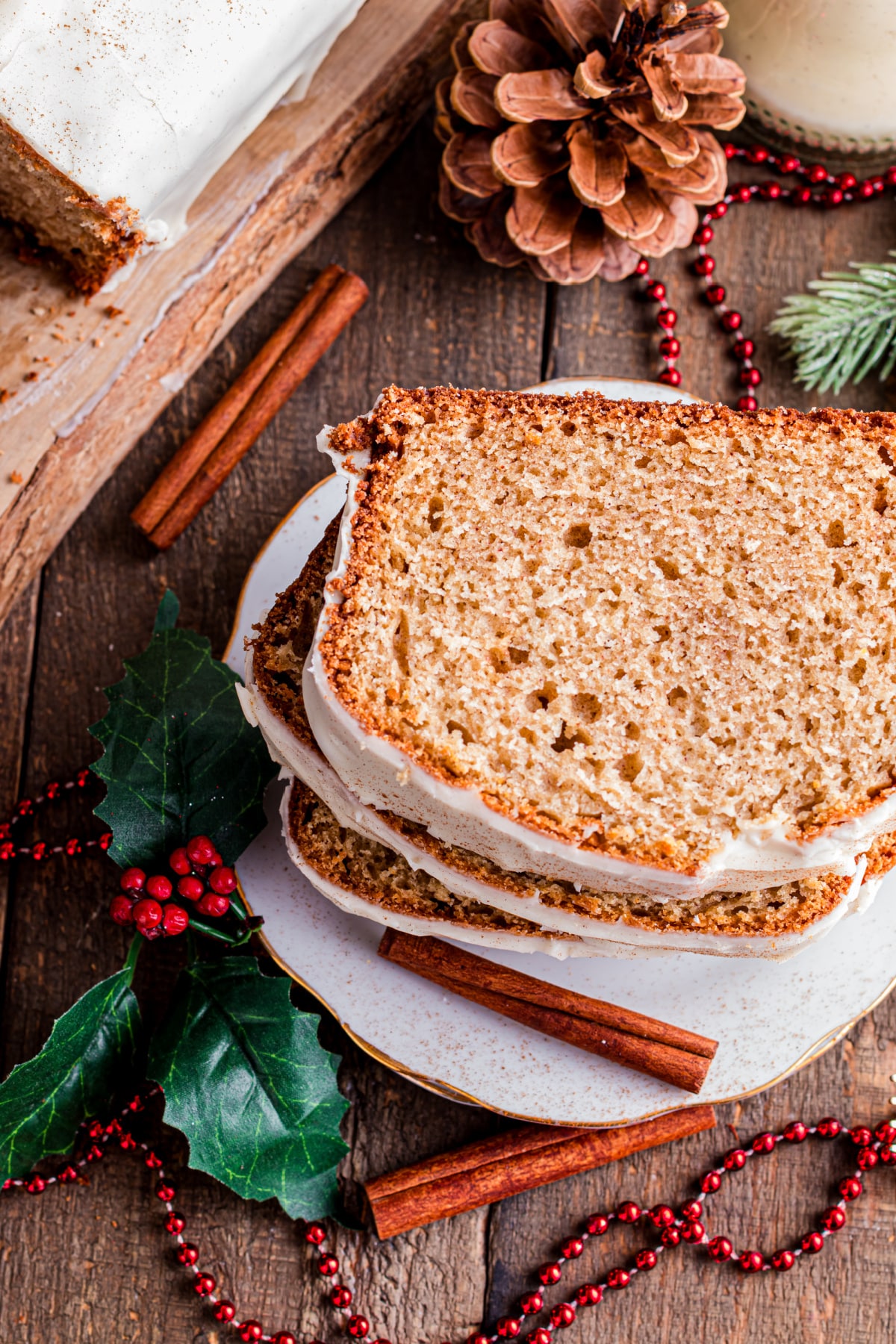Eggnog bread slices showing soft crumb and glaze Close-up of sliced eggnog bread with a set eggnog glaze, highlighting the tender crumb and warm spice throughout the loaf.