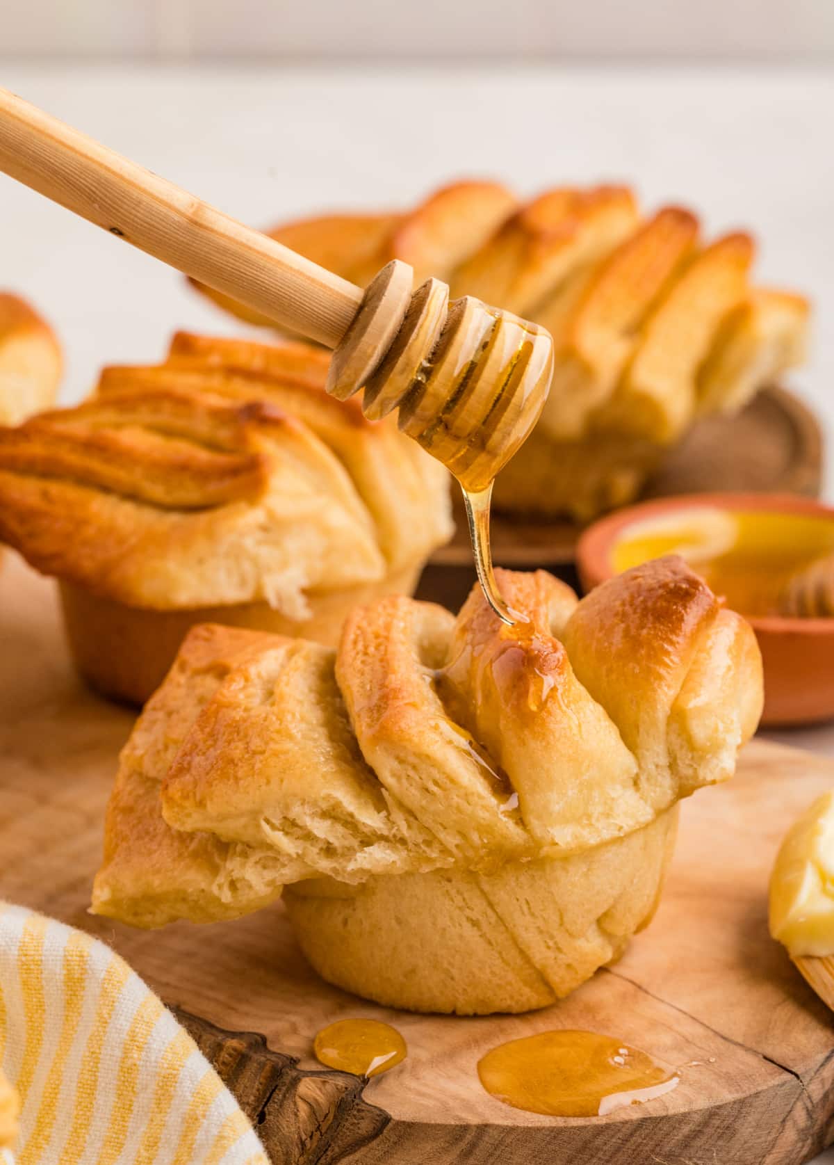 Honey butter pull-apart rolls finished with a drizzle of honey, highlighting the soft layers and golden baked edges. Honey butter pull-apart rolls drizzled with honey, showing soft layered folds and a tender interior.