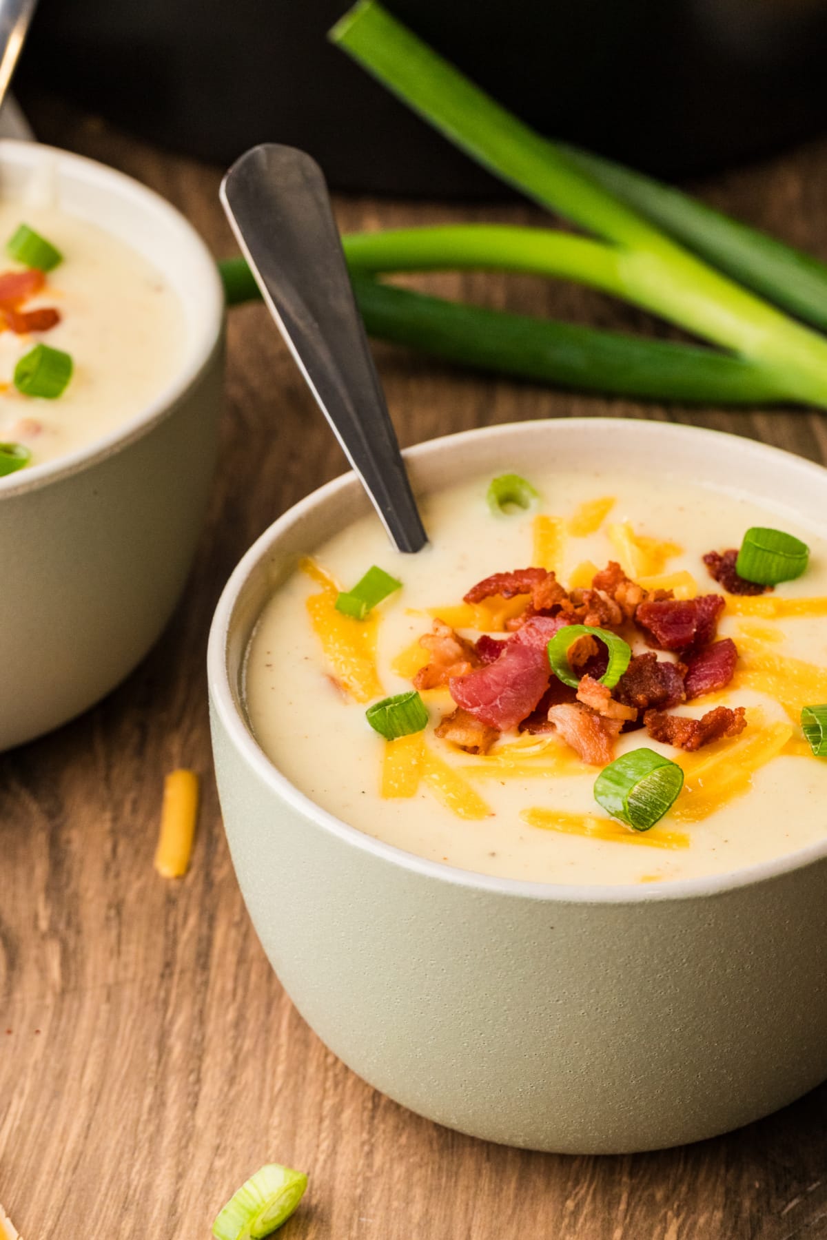 Creamy potato soup finished with bacon, cheddar, and fresh scallions. A bowl of thick, creamy potato soup topped with crisp bacon, shredded cheddar, and sliced scallions.
