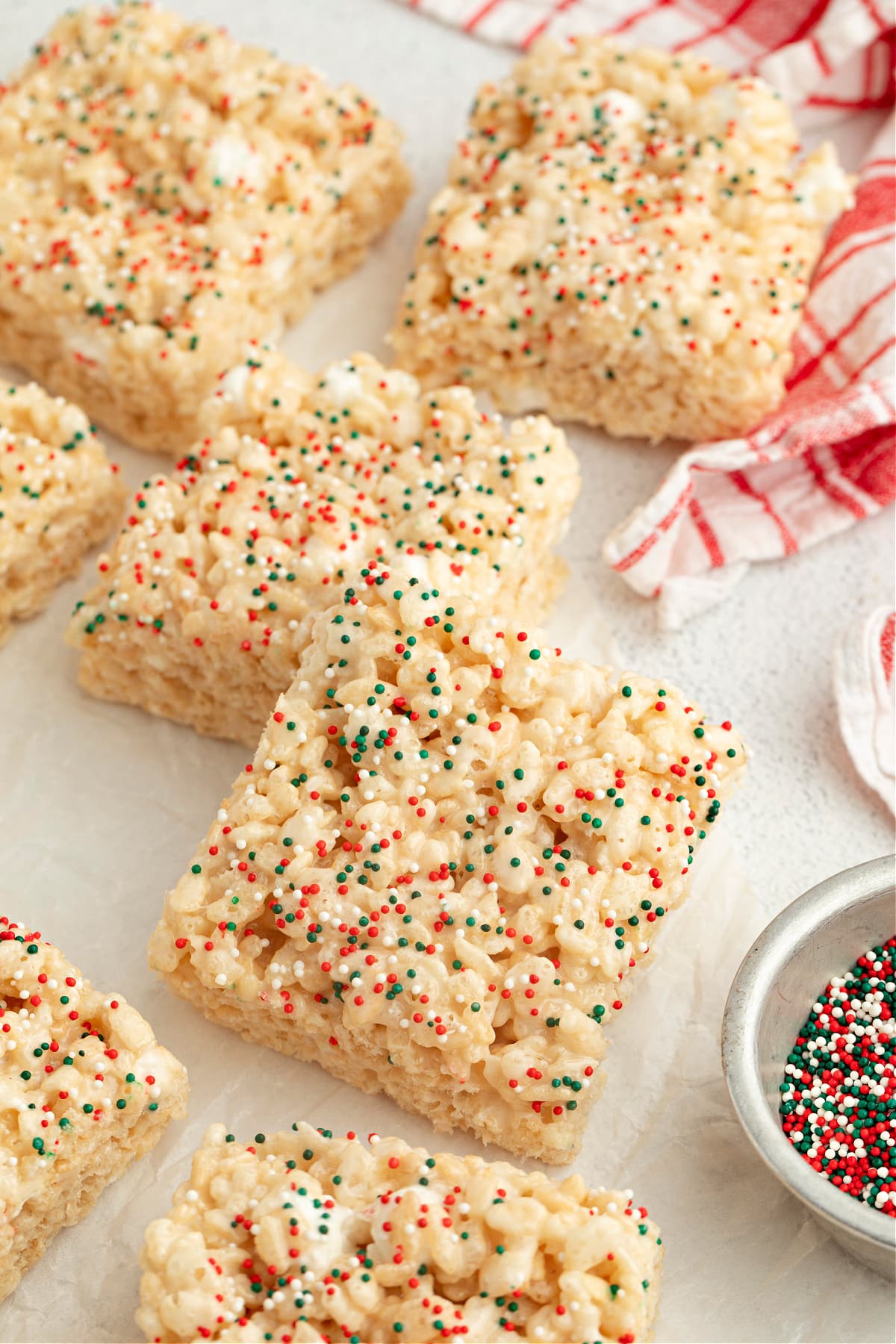 Christmas Sugar Cookie Rice Krispie Treats cut into thick squares and topped with red, green, and white holiday sprinkles.