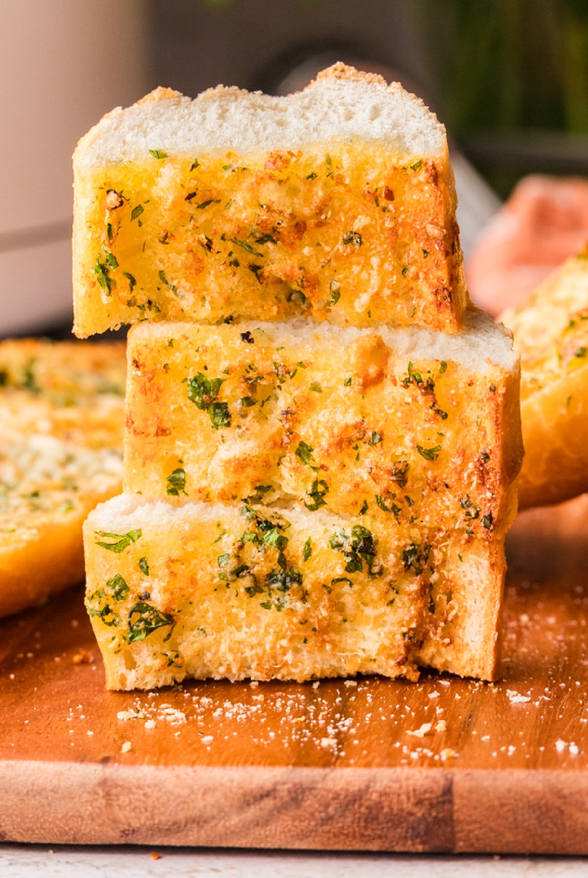 Thick slices of garlic confit bread stacked to show crisp edges and a tender crumb Stacked slices of crispy garlic bread made with garlic confit, showing a soft interior and golden crust