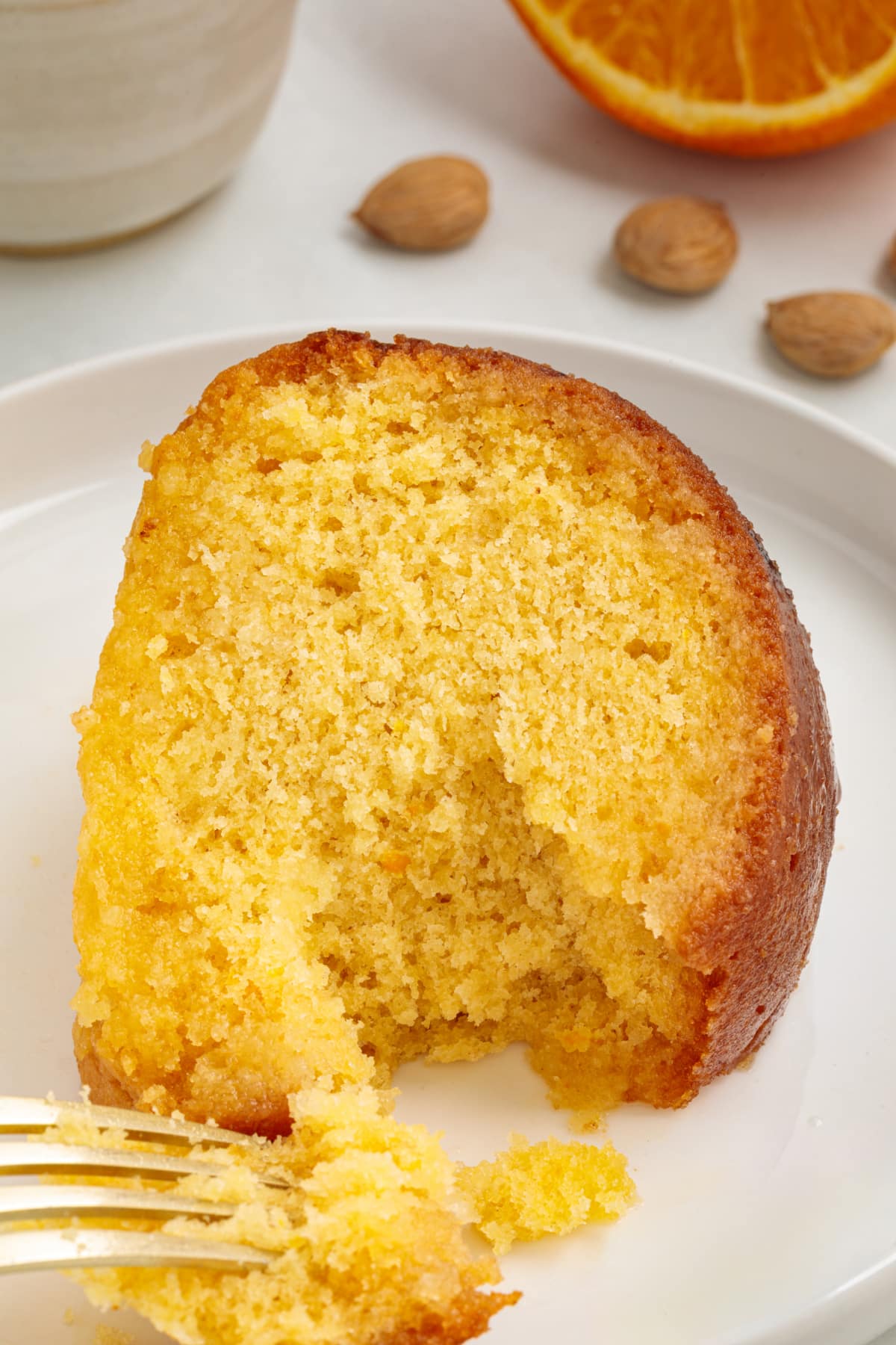 Citrus almond cake crumb close-up Moist citrus almond cake crumb with a fork breaking into the syrup-soaked center.
