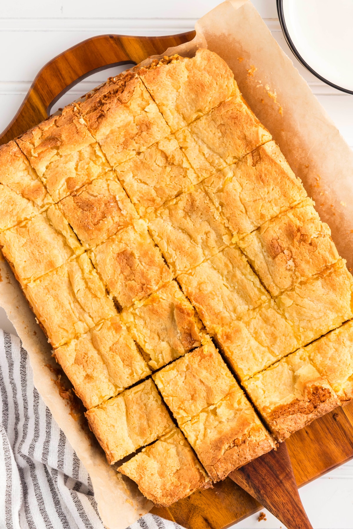 Gooey butter cake with a crackled top and soft, buttery interior. Freshly baked gooey butter cake viewed at an angle, highlighting the crackled surface and tender texture.