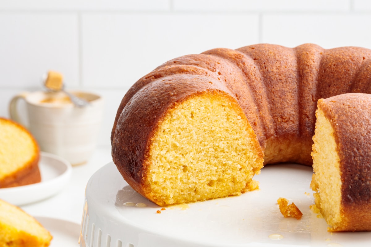 Olive oil Bundt cake with citrus syrup Syrup-soaked olive oil Bundt cake with a golden crumb on a cake stand.