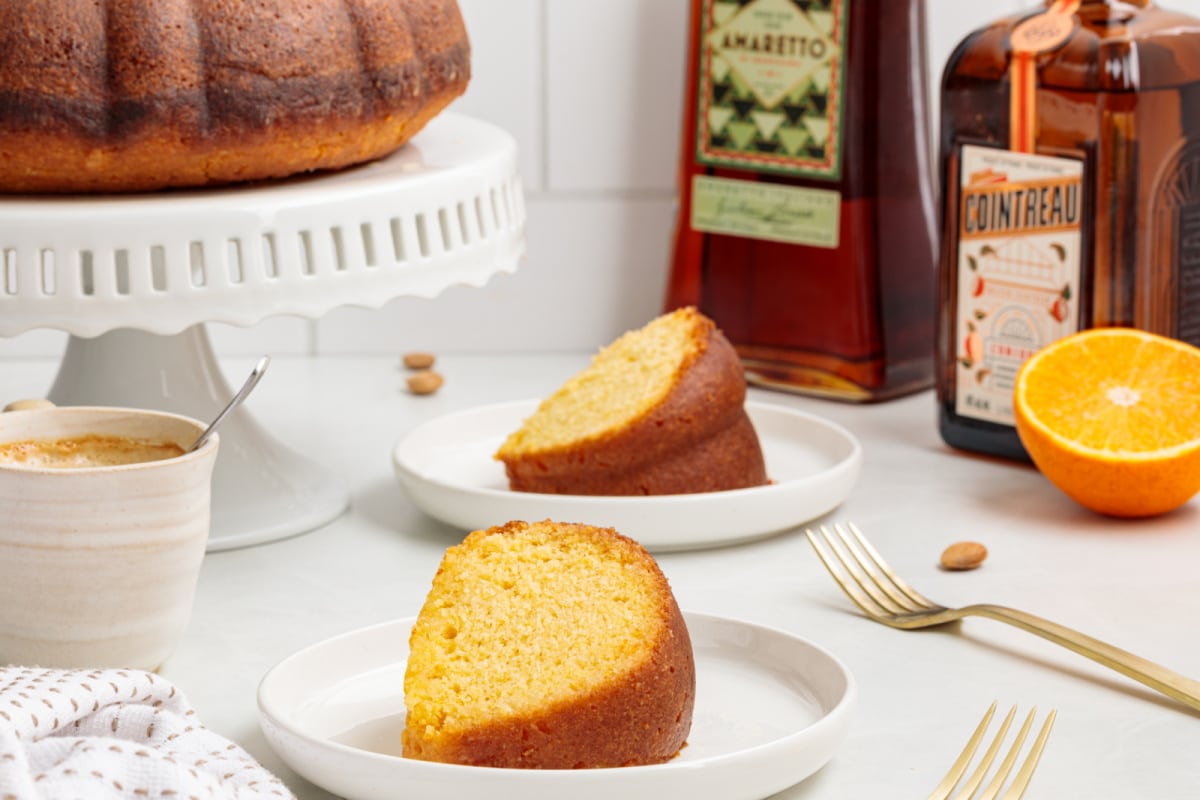 Almond citrus olive oil cake slice Slice of almond citrus olive oil cake served with espresso and liqueur bottles.