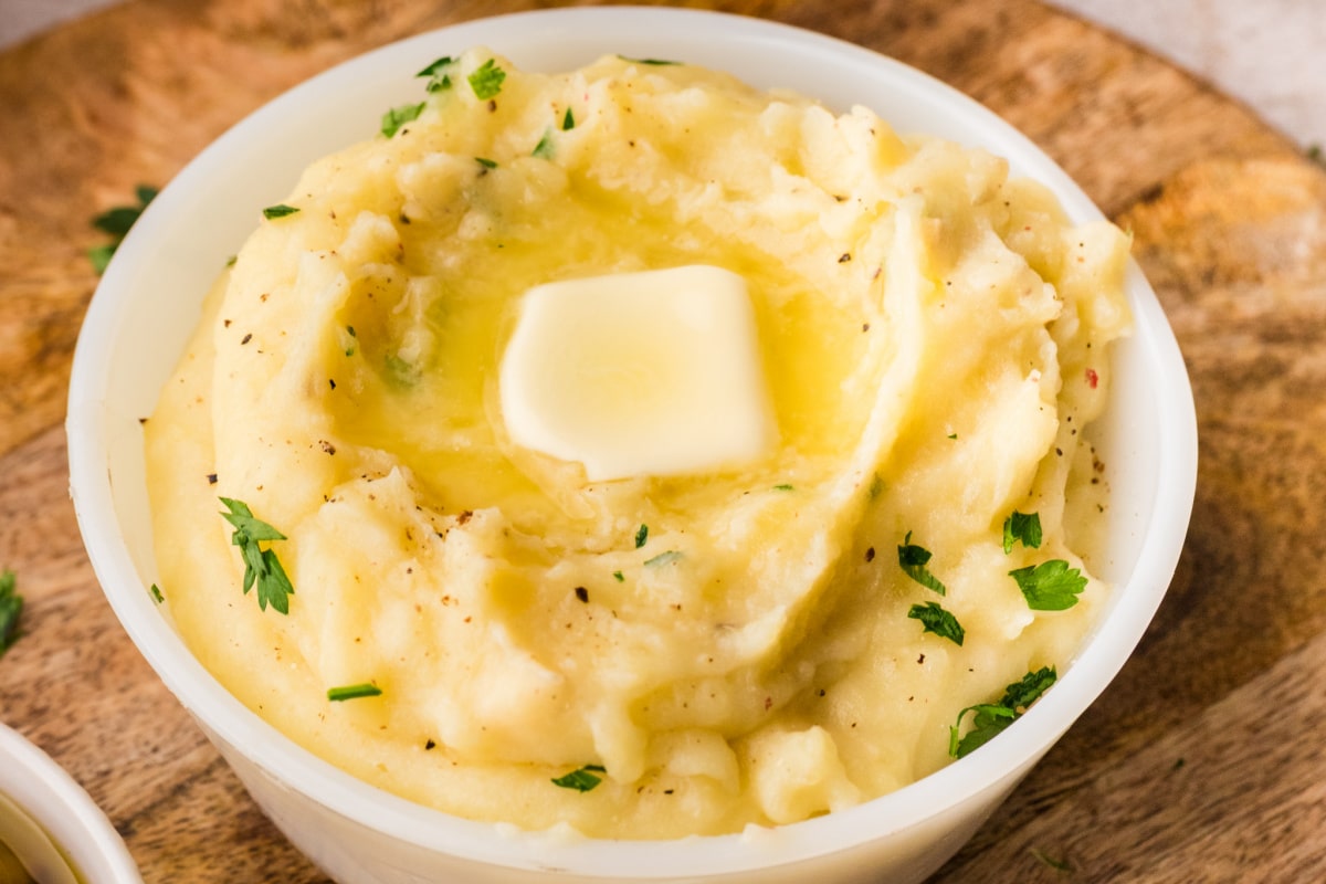 Creamy mashed potatoes made in the slow cooker with melted butter pooling in the center and a soft, fluffy texture throughout.