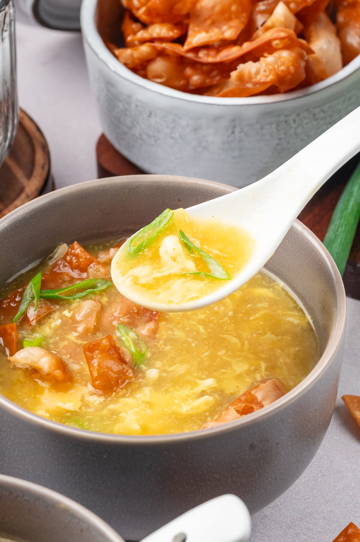 Close-up of egg drop soup showing soft egg ribbons and crispy wonton topping silky egg drop soup with fried wonton strips and delicate egg ribbons