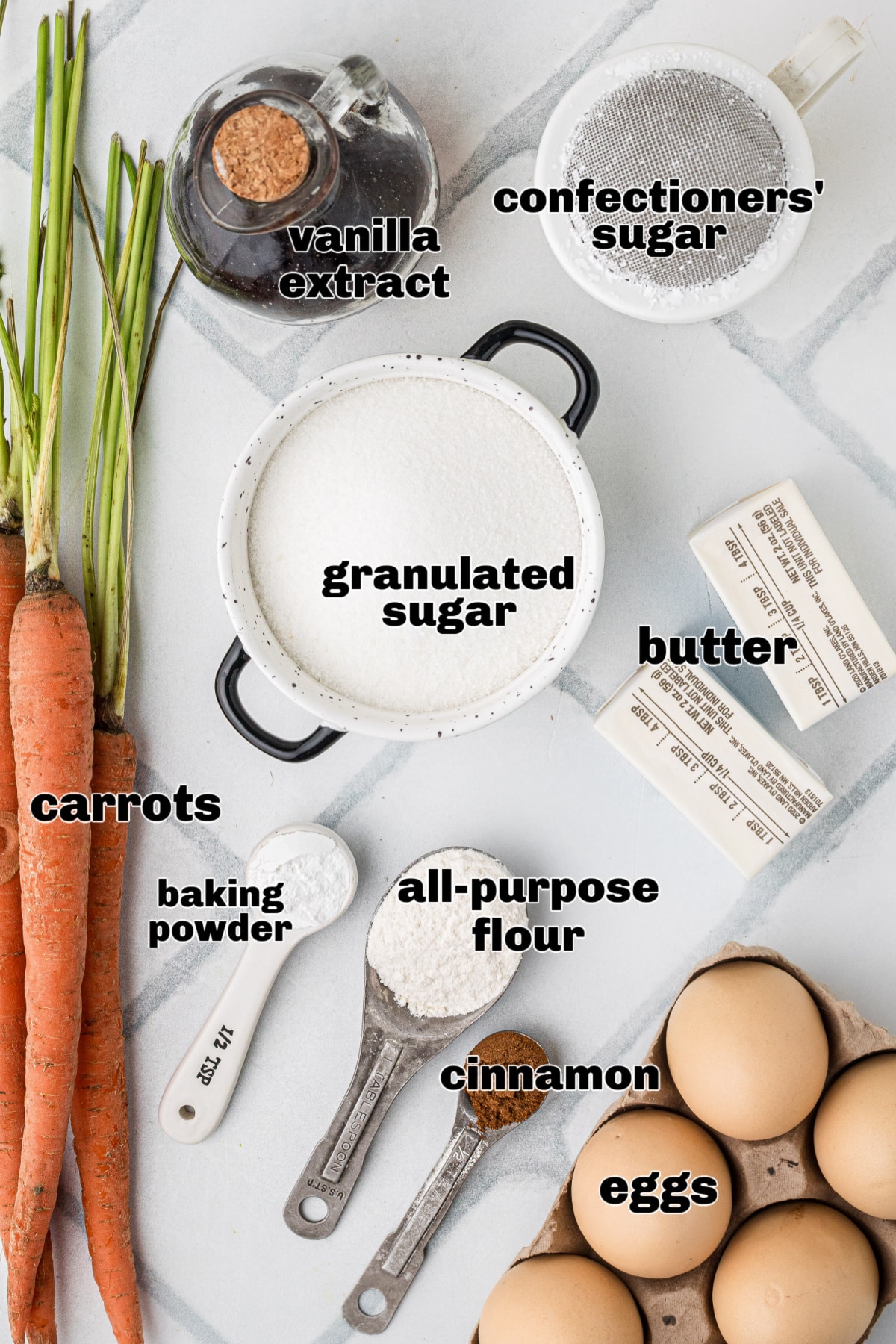 Carrot casserole ingredients on marble surface Ingredients for carrot casserole including carrots, eggs, sugar, butter, flour, baking powder, cinnamon, vanilla extract, and confectioners' sugar