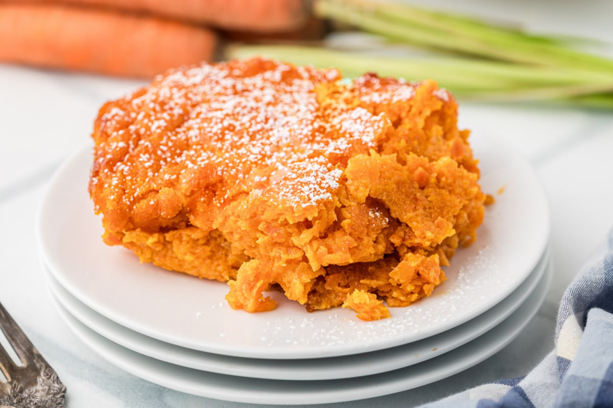 Carrot Souffle slice on plate with powdered sugar Slice of Carrot Souffle dusted with powdered sugar served on a white plate
