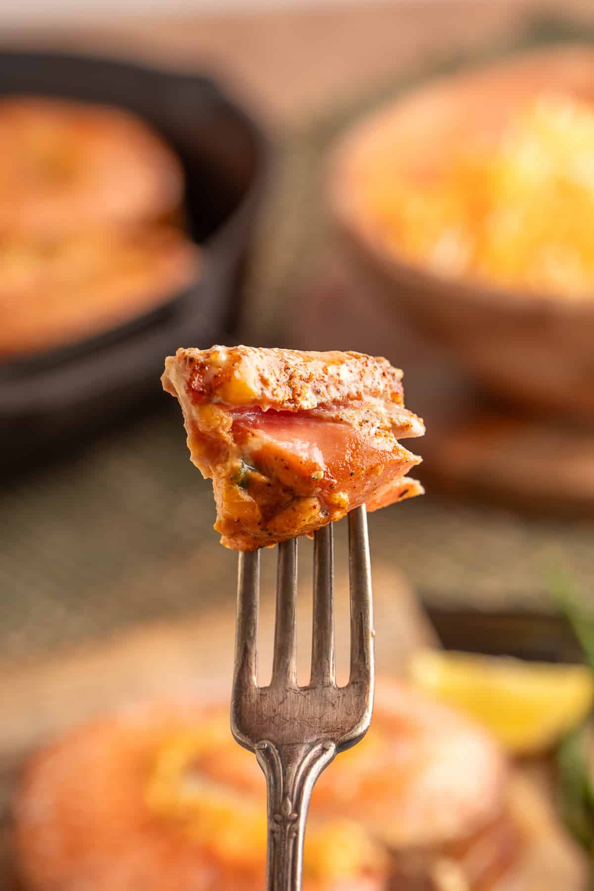 Close-up of a fork lifting a bite of baked stuffed salmon, showing tender layers of salmon and creamy jalapeño popper-style filling. Close-up of a fork lifting a bite of baked stuffed salmon, showing tender layers of salmon and creamy jalapeño popper-style filling.