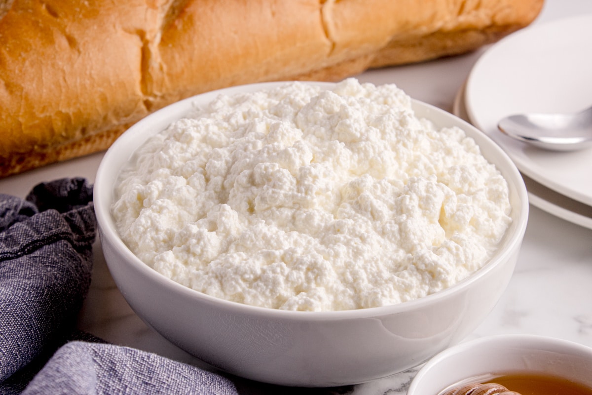 Bowl of freshly made homemade ricotta cheese with soft, creamy texture Creamy homemade ricotta cheese in a bowl on the counter