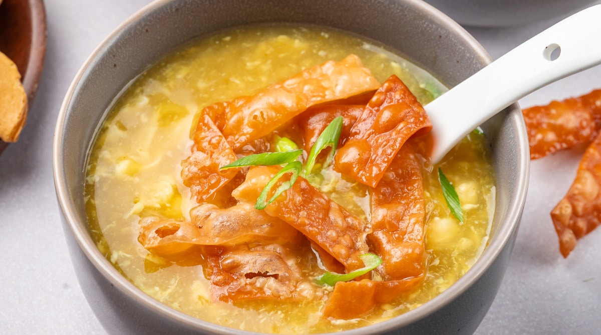 Egg drop soup with crispy wonton strips, glossy broth, and tender egg swirls
