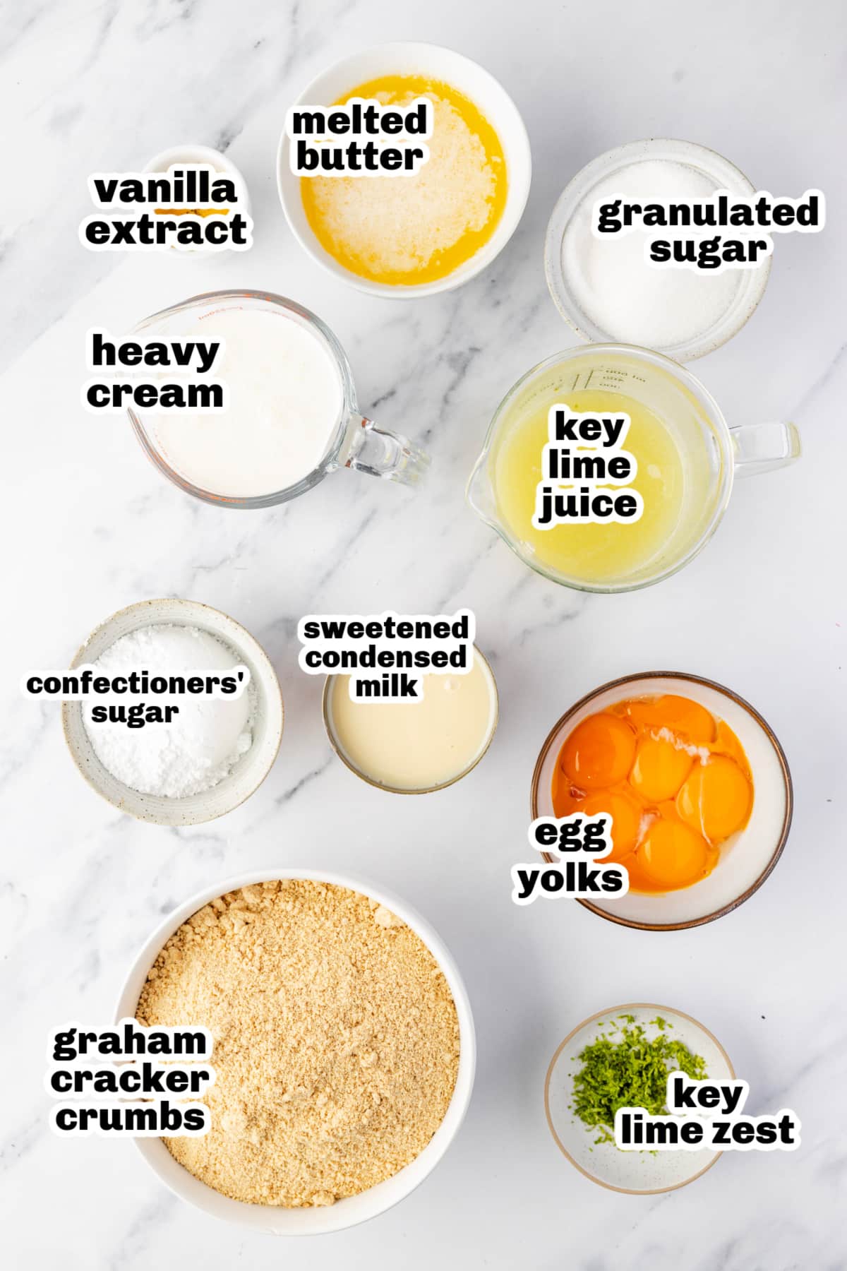 Measured ingredients for crust and filling Ingredients for lime custard bars including sweetened condensed milk, egg yolks, graham cracker crumbs, and key lime juice