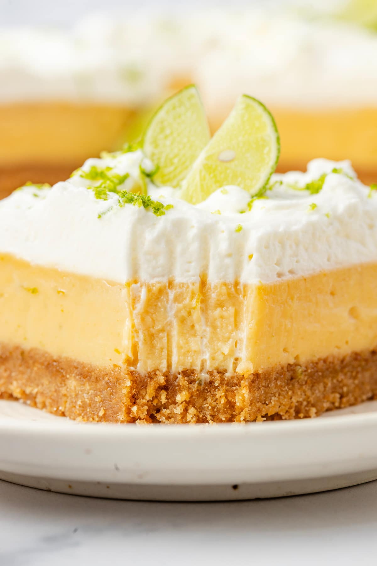 Tall layered custard slice close-up Close-up of thick lime custard slice with whipped cream topping and graham cracker crust