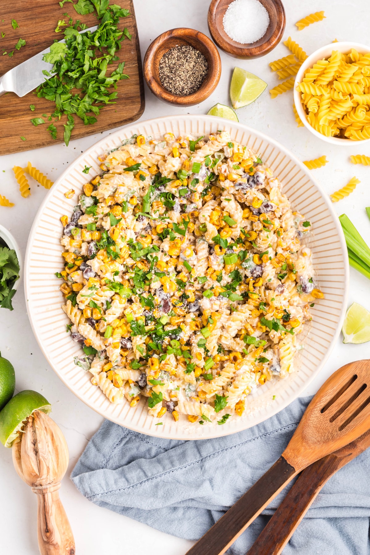 Creamy pasta salad with sautéed corn, black beans, cotija, and herbs, ready for serving Mexican street corn pasta salad served in a large bowl with chopped cilantro, green onions, and golden corn