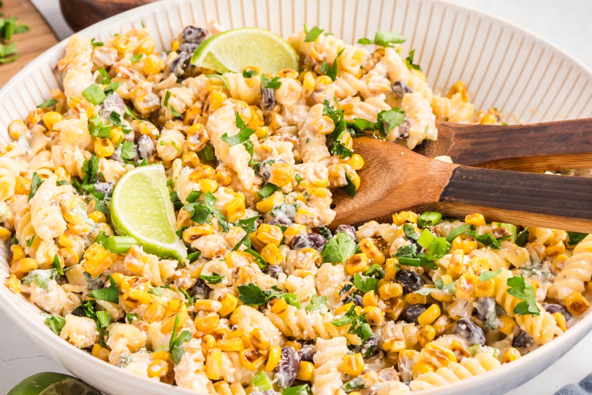 Mexican street corn pasta salad tossed with creamy chili-lime dressing, featuring blistered corn, rotini pasta, black beans, cotija cheese, and fresh herbs Mexican street corn pasta salad served as a creamy side dish with rotini, golden corn, black beans, cotija, and fresh cilantro